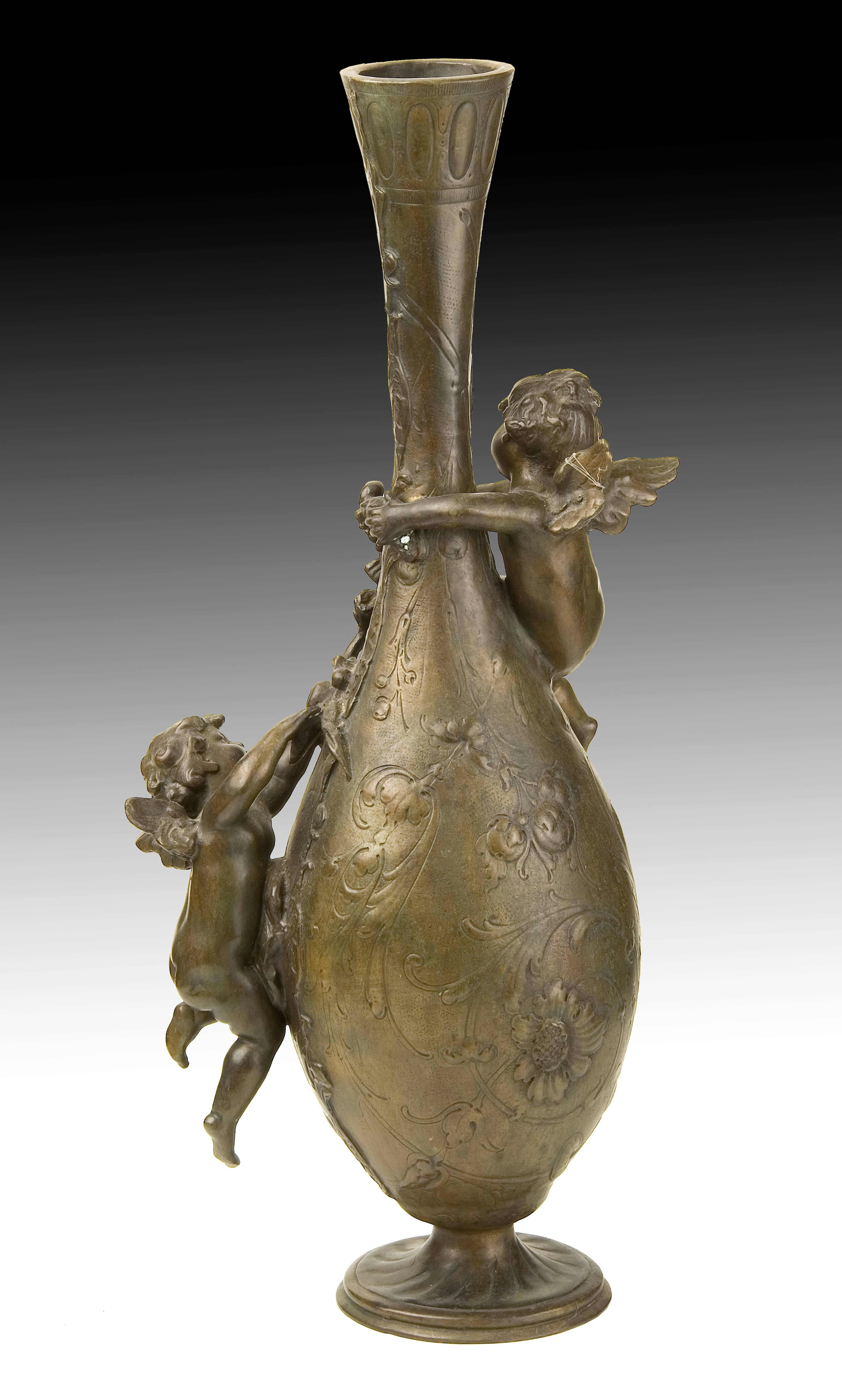 Bronze vase with cherubs or cupids, 19th-20th centuries.
Vase with circular base, oval body and elongated neck decorated with two figures of cupids or cherubs and a series of elements and flowers of clear neoclassical influence. This type of