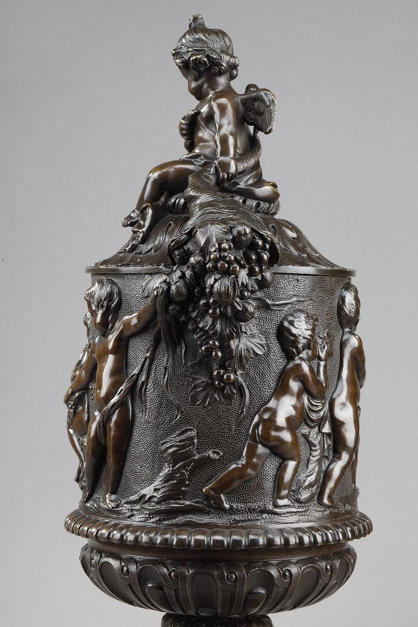 Patiné Vase en bronze avec putti récoltant dans la cueillette de Clodion, 19ème siècle en vente