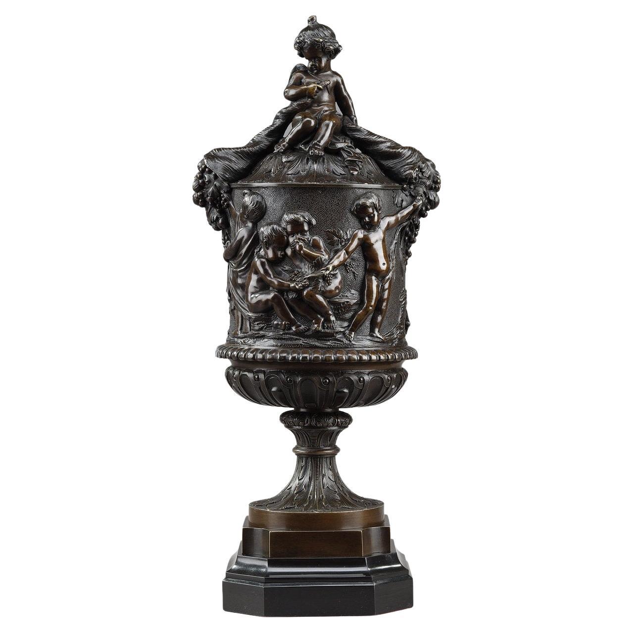 Vase en bronze avec putti récoltant dans la cueillette de Clodion, 19ème siècle en vente