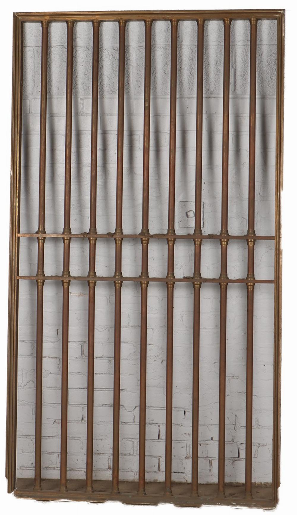 Bronze vault door and a pair of matching panels C 1910. The set is comprised of a door having 9 turned bars within a flat, rectangular frame. It has a lock but no hinges. 81.5