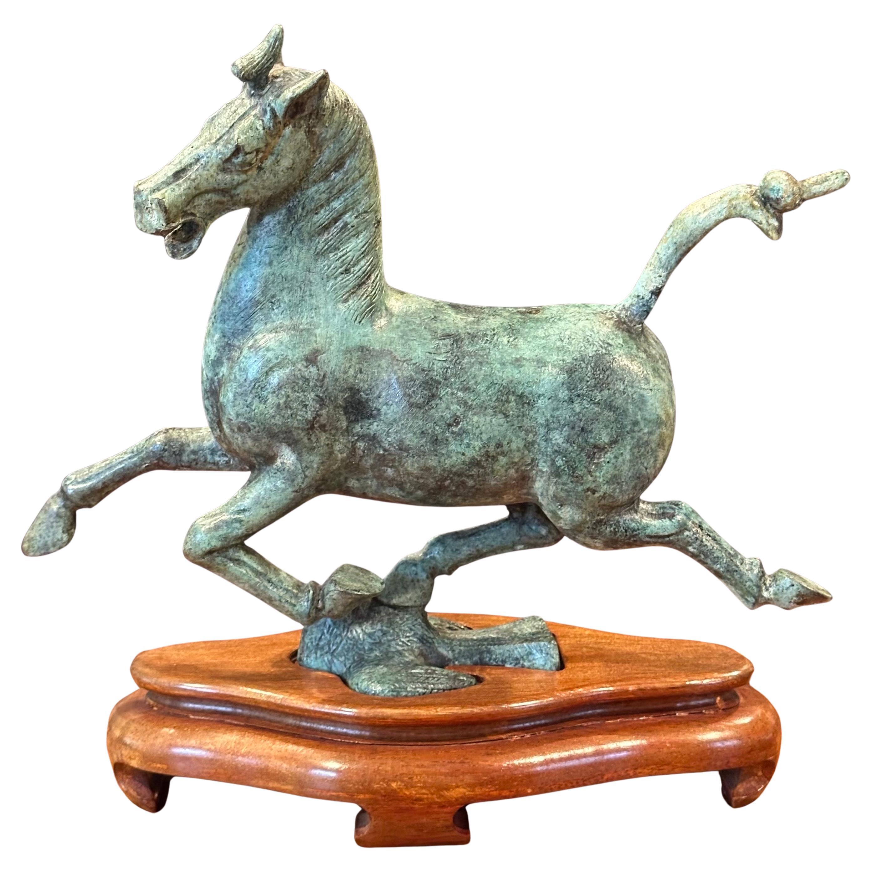 Splendida scultura di cavallo cinese T'ang in bronzo verdastro su base in legno, circa anni '70. Modellata sulla base di un cavallo reale scoperto durante il periodo della 