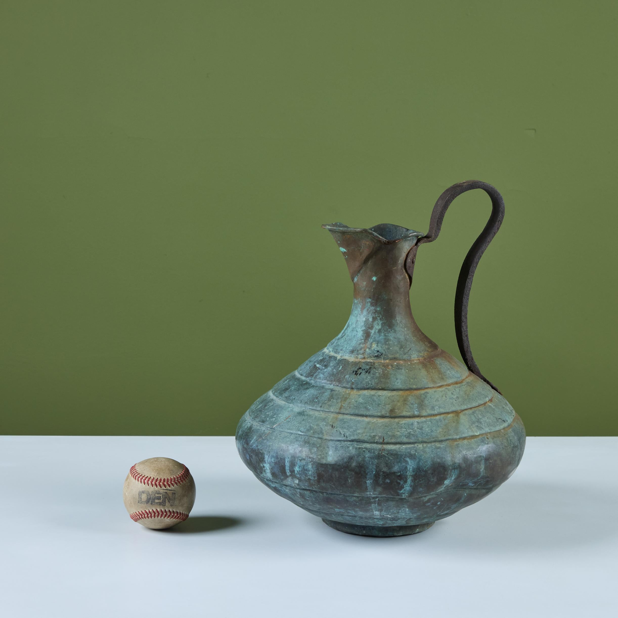 Bronze pitcher featuring a bulbous body with ribbing around the circumference and a curved handle. 


Dimensions
12