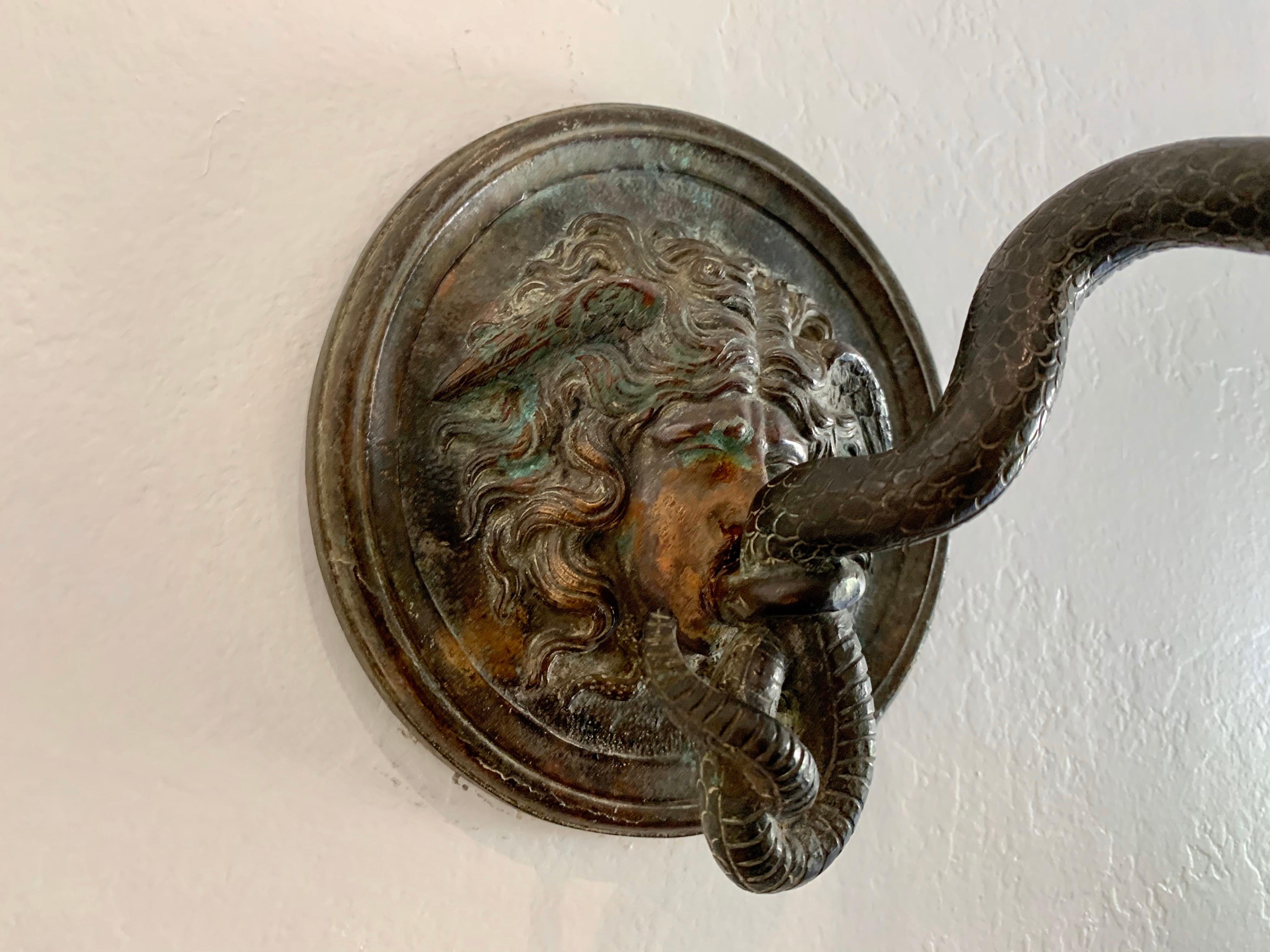 A most unusual cast bronze wall hook with the face of Medusa and a scrolled snake with hook. Nice dark patina in great antique condition. Stamp impressed upon foundry frame (see detail images). Theme is based on the story of Perseus and Andromeda,