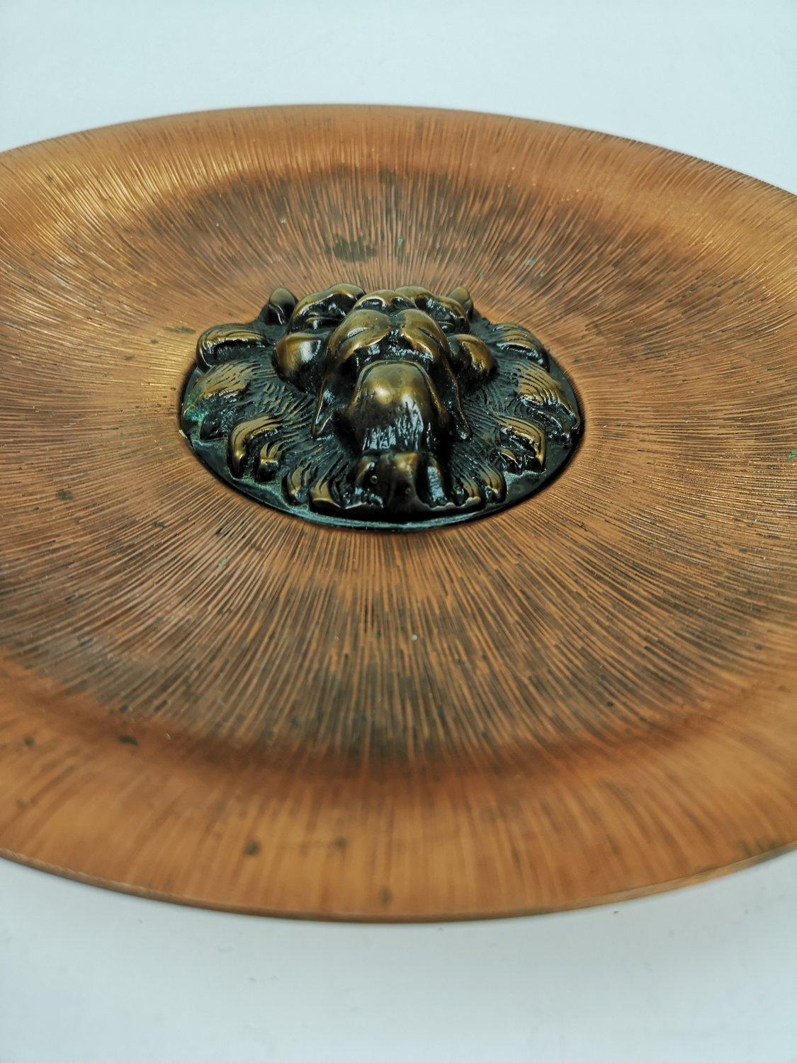 Decorative bronze wall plate with a stylized lion head in the middle. The copper surface features an extraordinary and beautiful copper surface. An outstanding Mid-Century Modern decorative item.