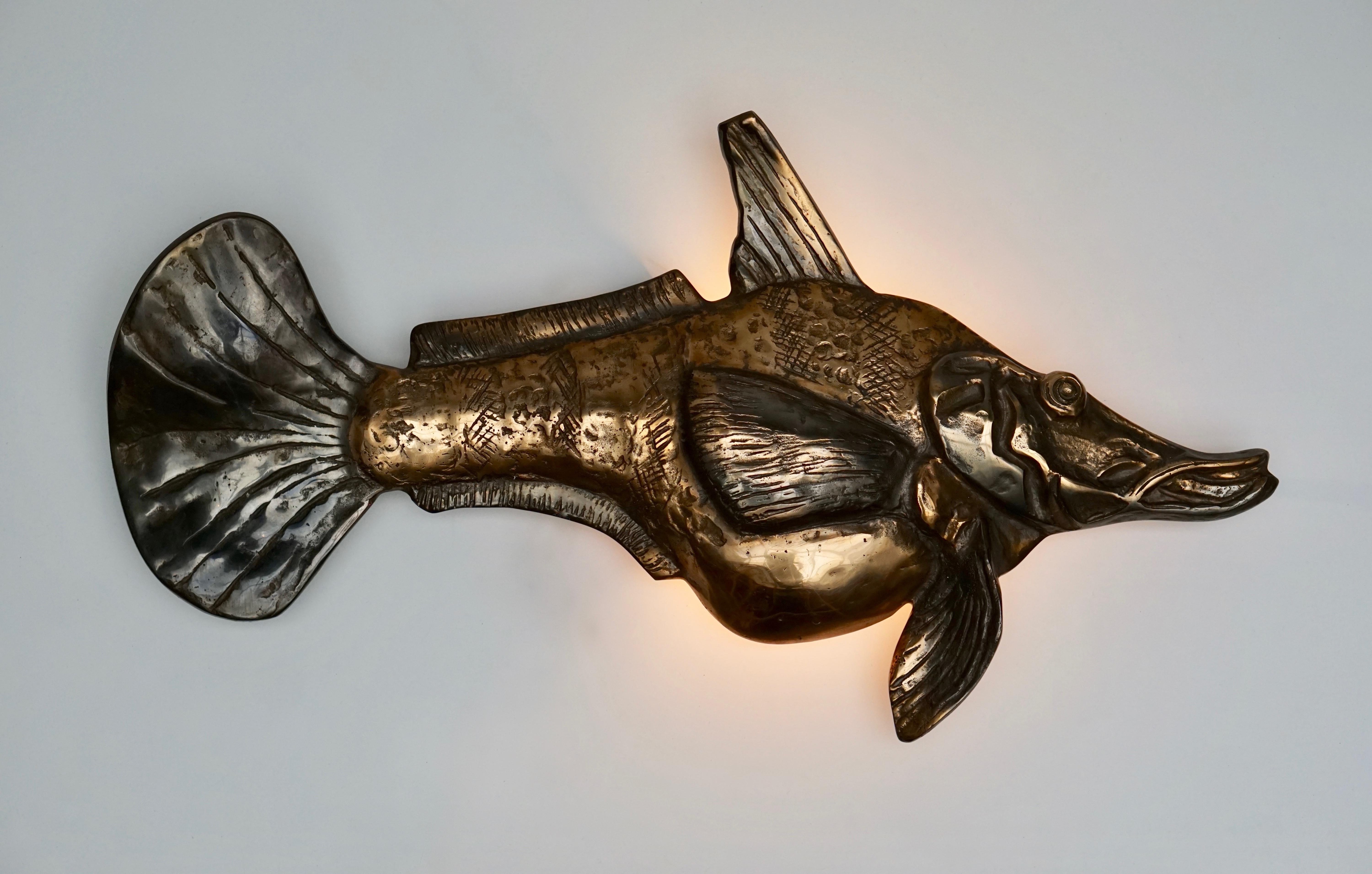 Bronze wall light sculpture in the shape of a fish.
Measures: Width 70 cm, height 38 cm, depth 10 cm.
Weight 6 kg.
One E14 bulb.