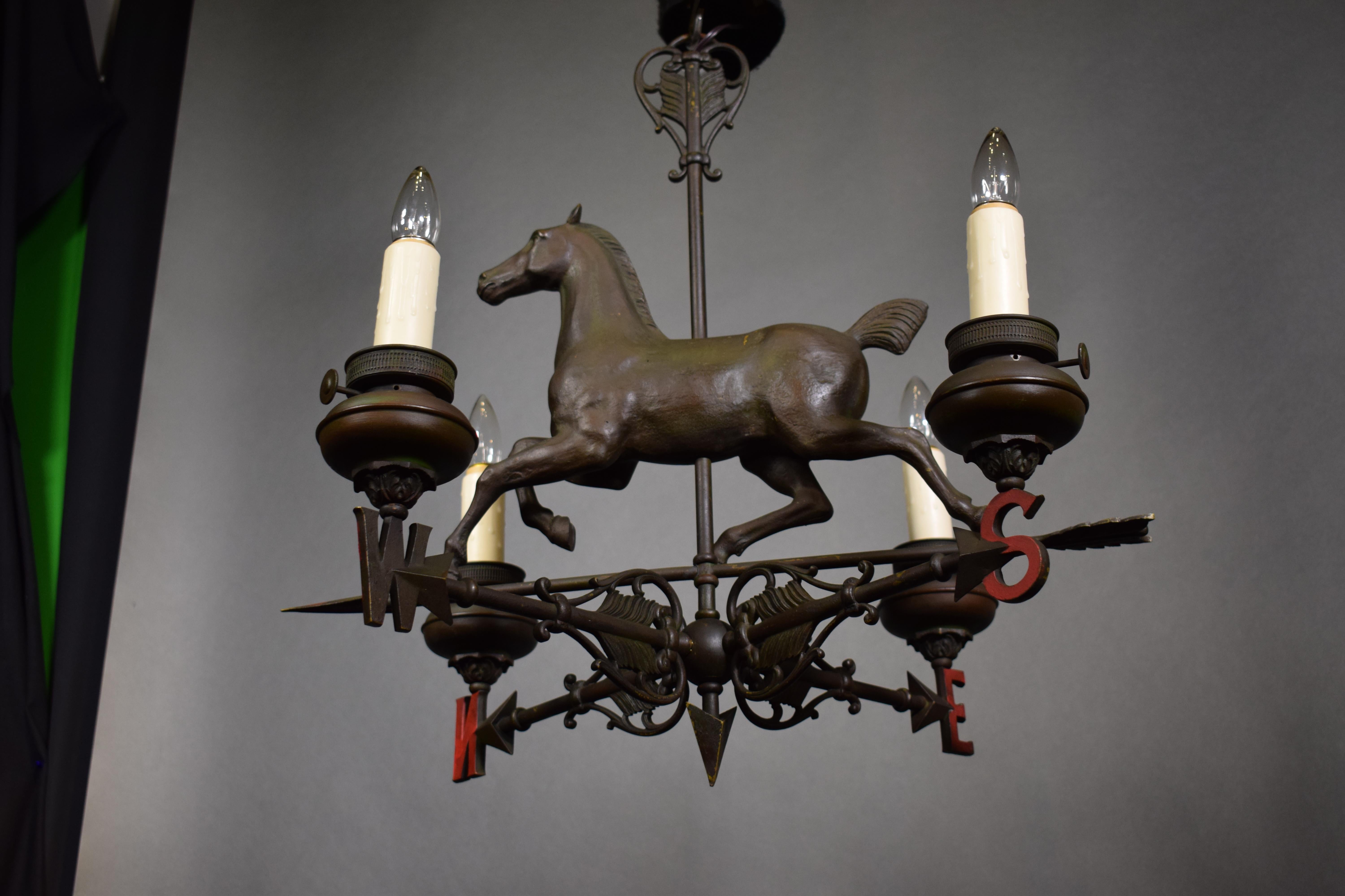 A fine and unusual all bronze chandelier depicting a Horse on weathervane. England, circa 1900. 4 Lights.
Dimensions: Height 25