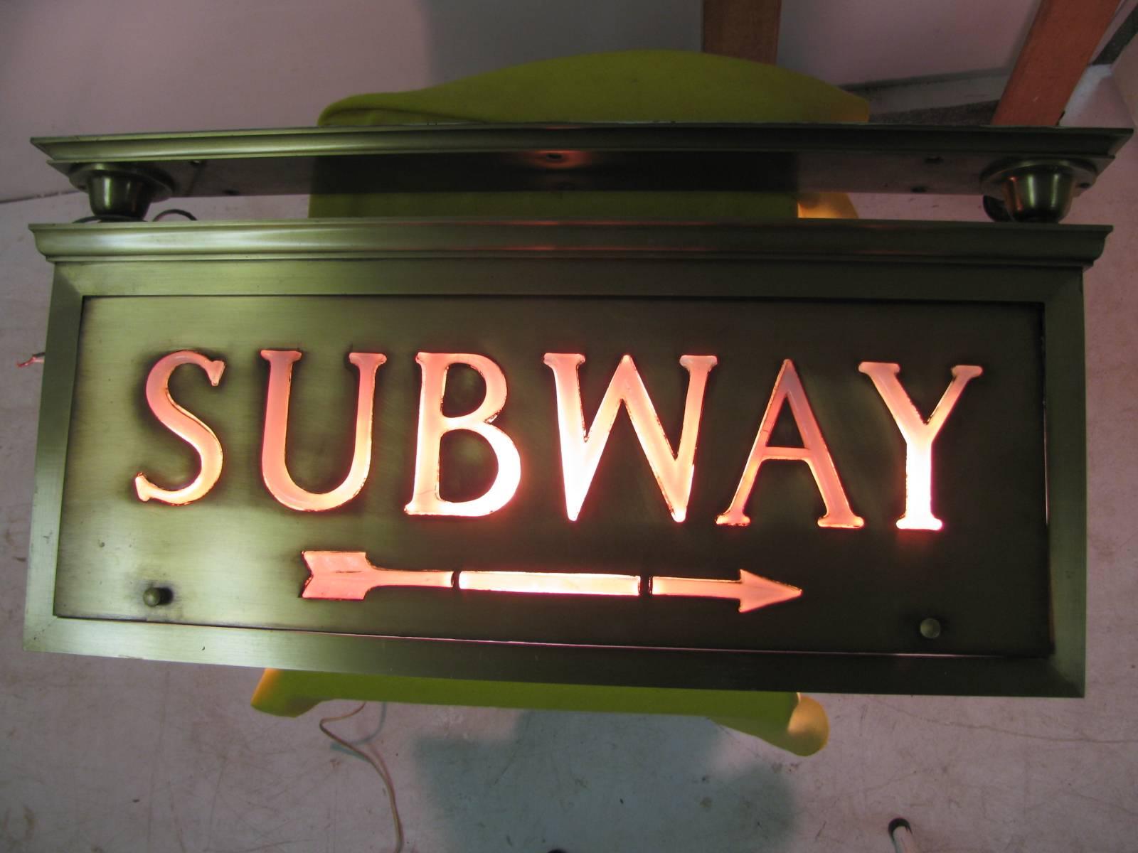 Spectacular and rare brass with individual letters handcrafted Tiffany glass. Opalescent glass letters and three-piece arrow comprise the fixture housed in bronze. Originated inside of a NYC building with access to the subway. Sign is double sided.