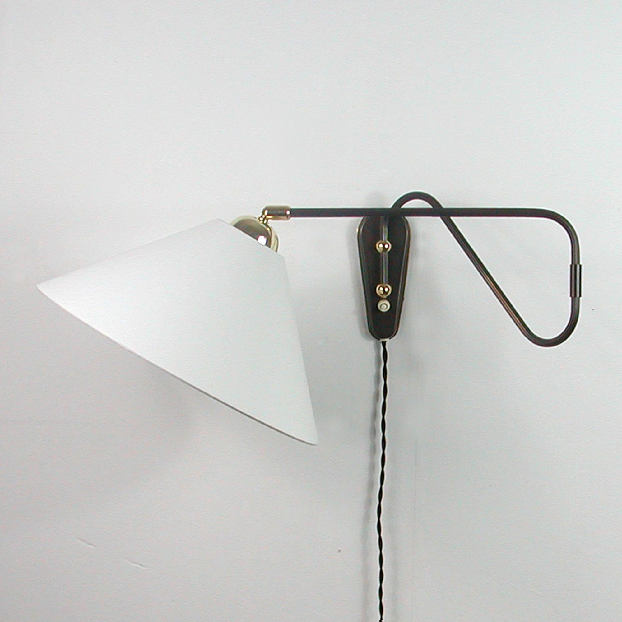 This unusual 1950s adjustable and articulating vintage wall light was designed and manufactured in Germany by Cosack Leuchten.

The lamp features an off-white fabric lampshade and bronzed brass articulating lamp arm with brass details. The lamp