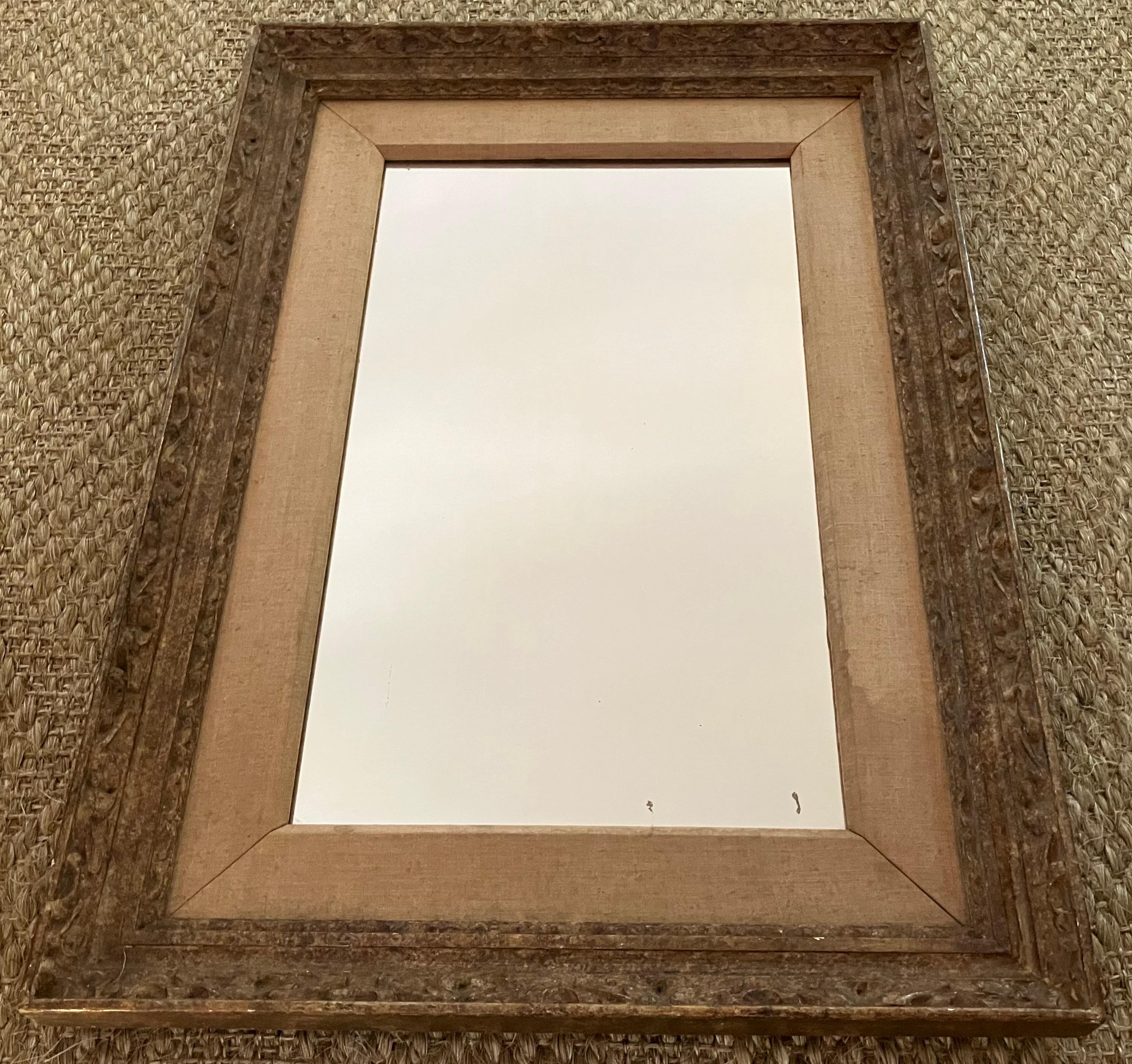 Bois sculpté bronzé Miroir. Miroir Vintage des années 20 avec cadre en bois sculpté peint dans les tons bronze doré et argenté et doublure en lin chamois d'origine par House of Heydenryk.
Dimensions : 30 