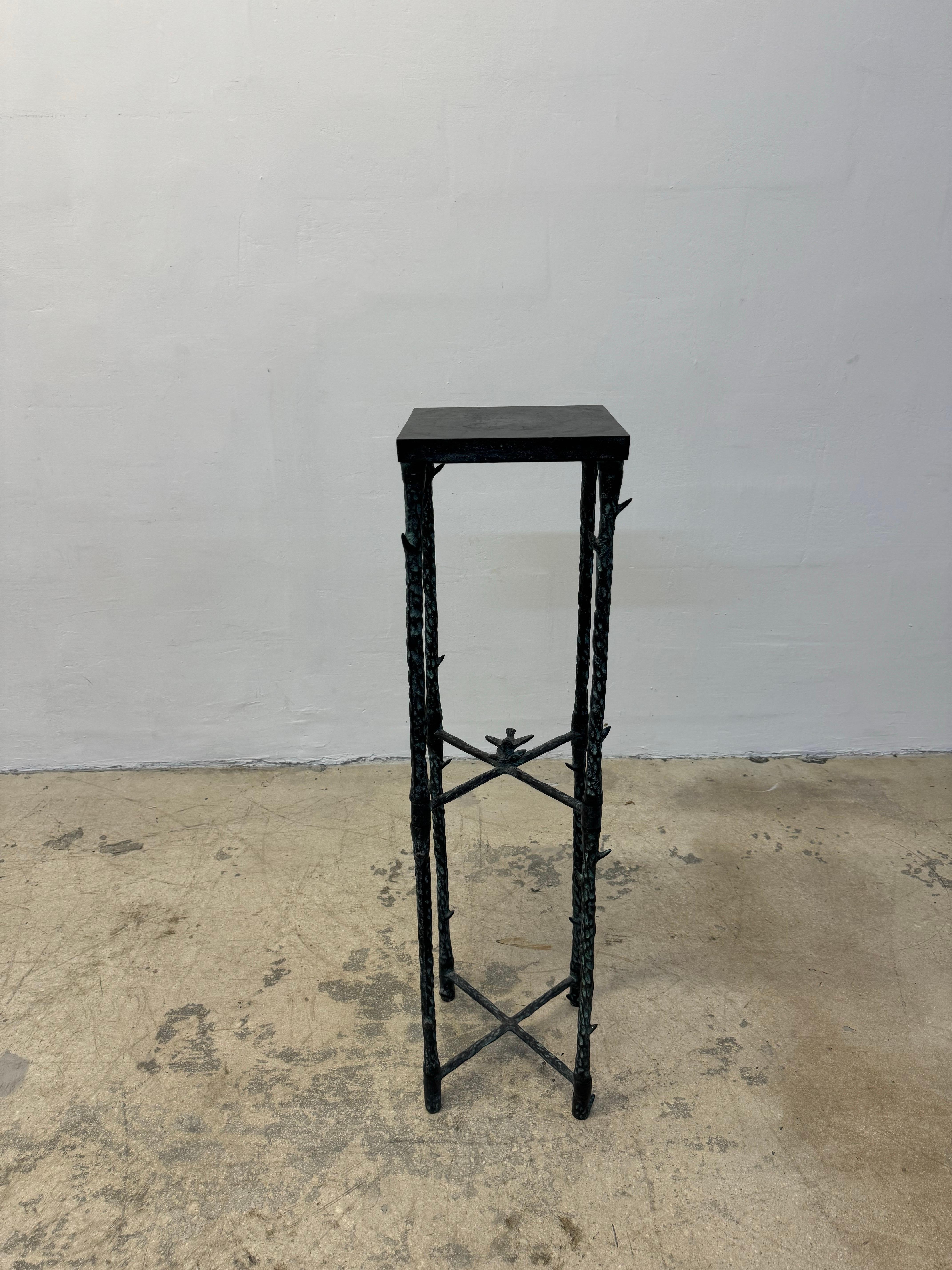Alberto Giacometti inspired pedestal stand with a faux aged dark green bronze patina, faux bois legs and a bird perched on a branch in the cross stretchers.