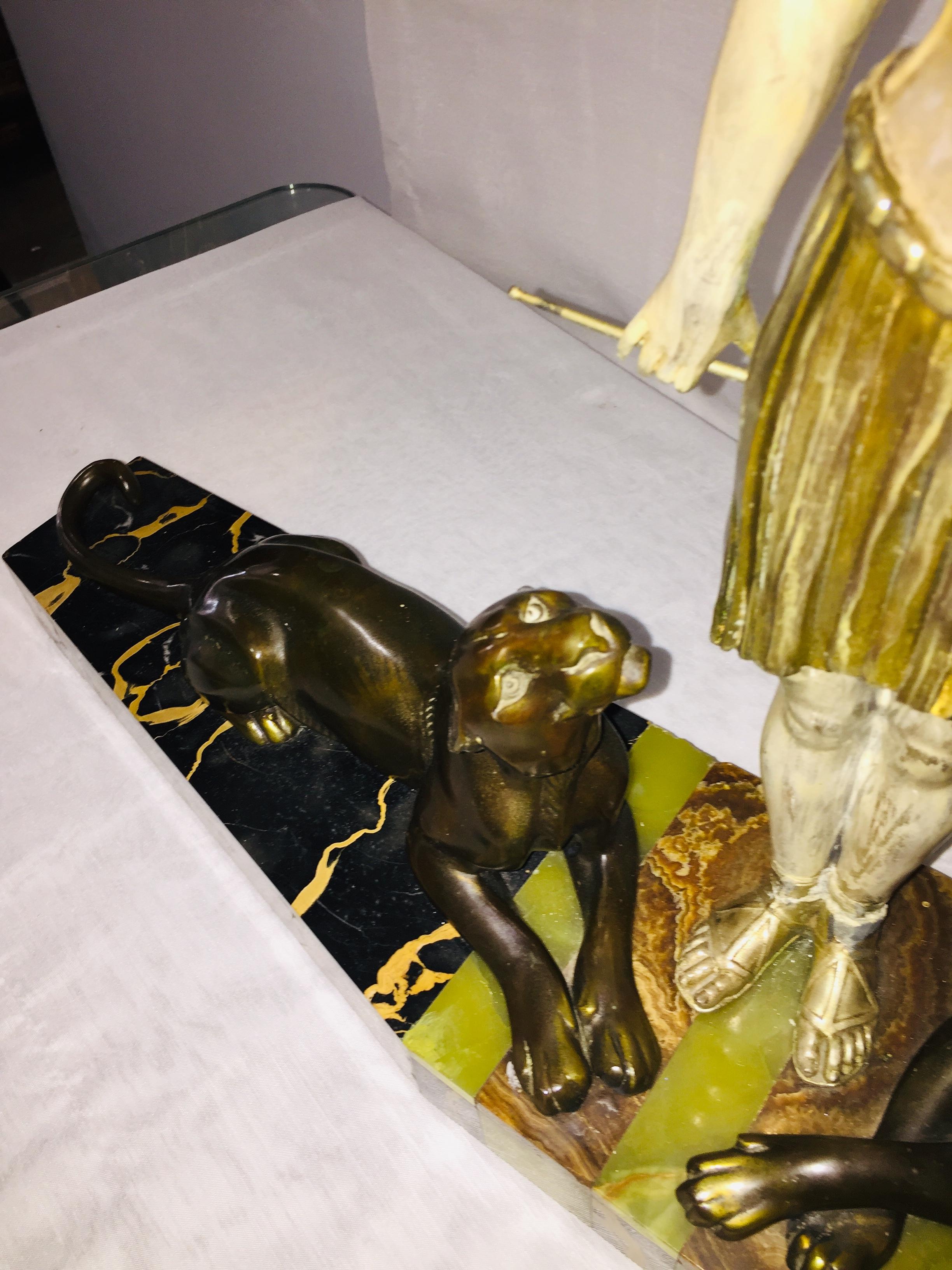 Female tamer figure with two panthers lying on each side of the marble base,
The two animals looking at her, she is wearing a typical dress from the fashion circa 1930.
Very expressive attitudes of the animals, strong Art Deco design for this