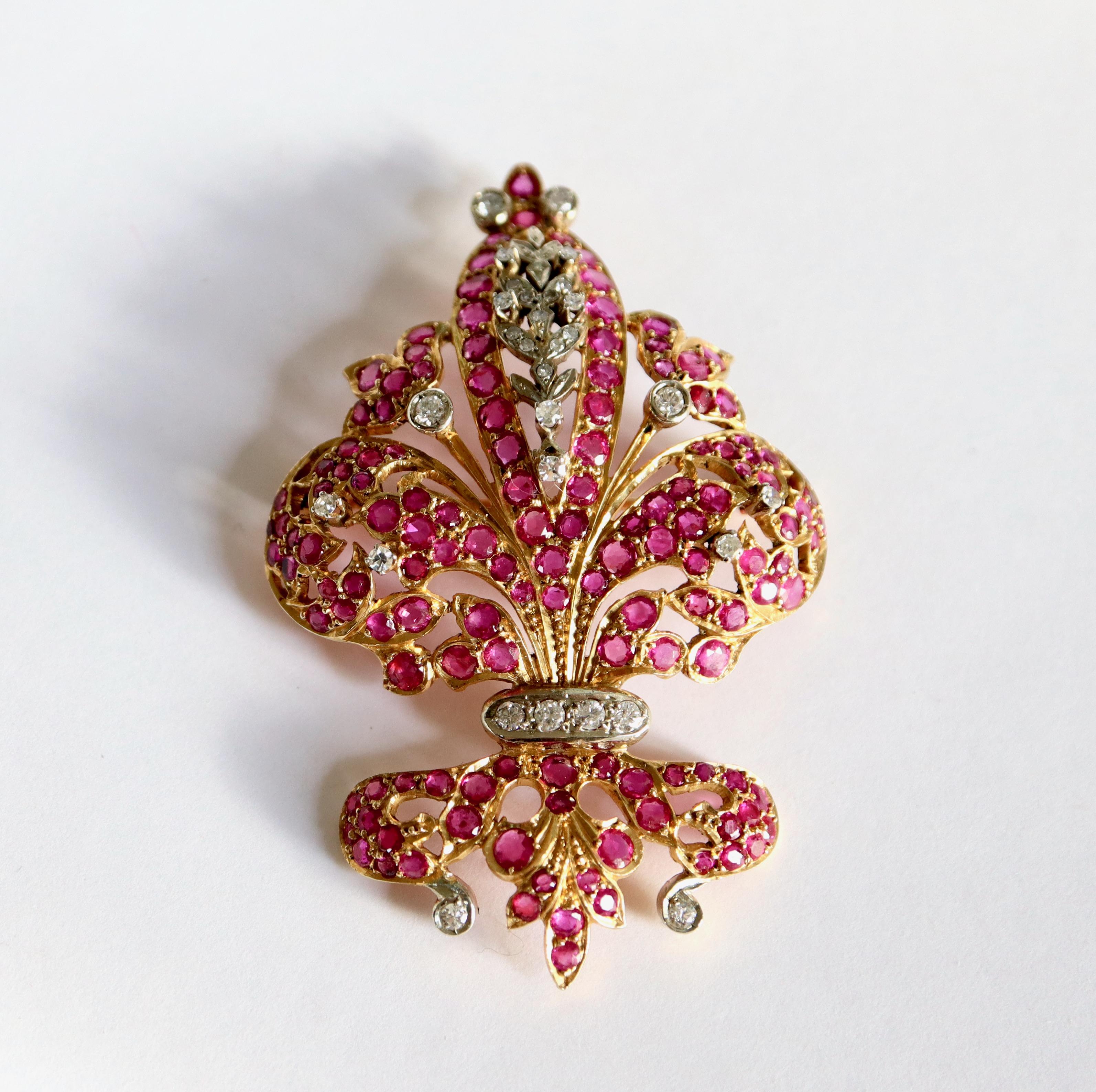 Heraldic Lily brooch in 18 kt gold, rubies and diamonds.
Brooch holding a fleur-de-lys design punctuated with a pavé of rubies and brilliant-cut and 8/8 diamonds. Setting in 18K yellow gold and white gold. Dimensions: 6.7 x 4.4 cm. Gross weight: