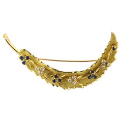 Brooch in a shape of a feather with sapphire and brilliant cut diamonds 18k gold