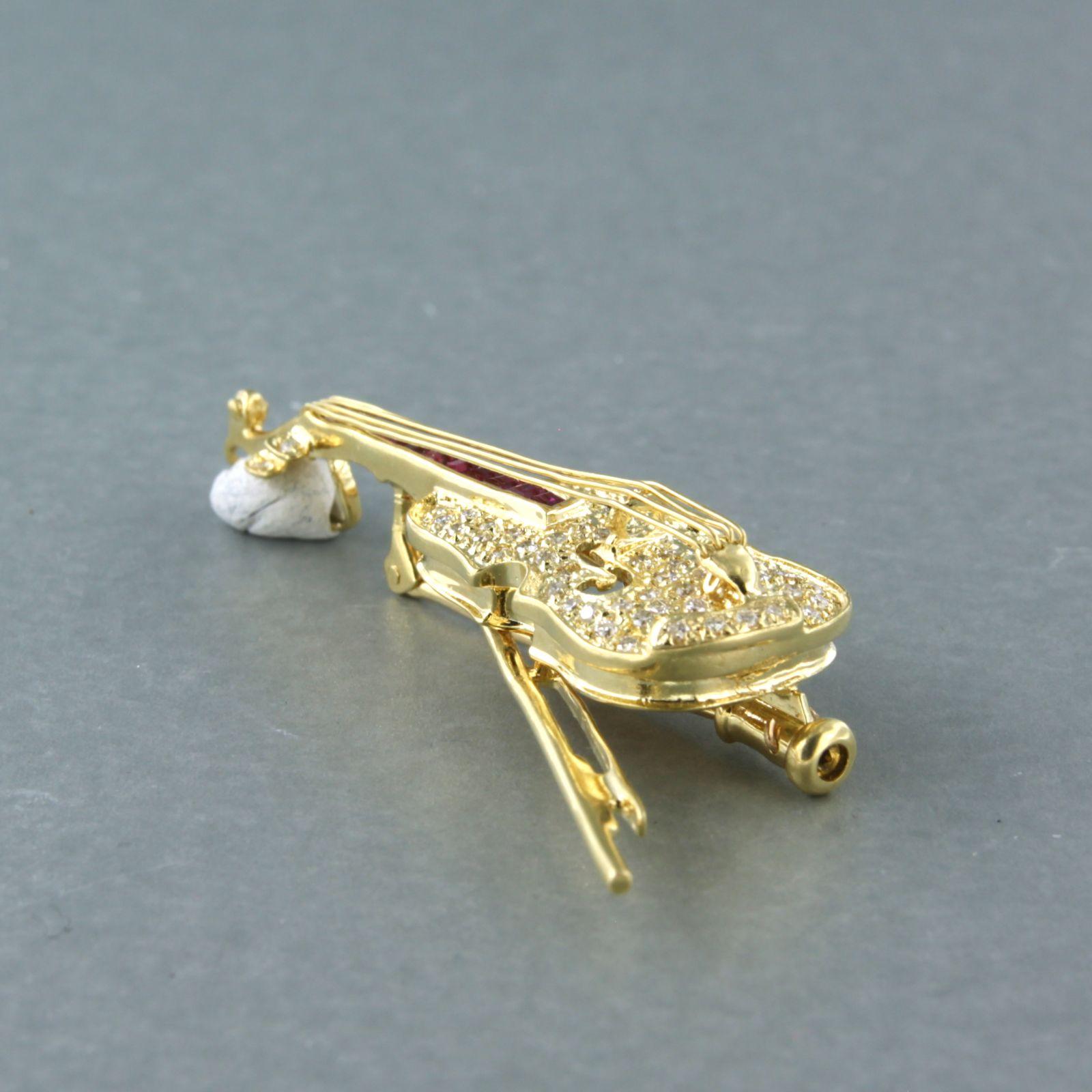 18k yellow gold brooch in the shape of a violin set with ruby ​​brilliant diamonds. 0.40ct – G/H – VS/SI - size 5.3 cm x 2.5 cm

Detailed description

the size of the brooch is 5.3 cm by 2.5 cm wide

weight 9.5 grams

set with

- 10 x 2.0 mm square