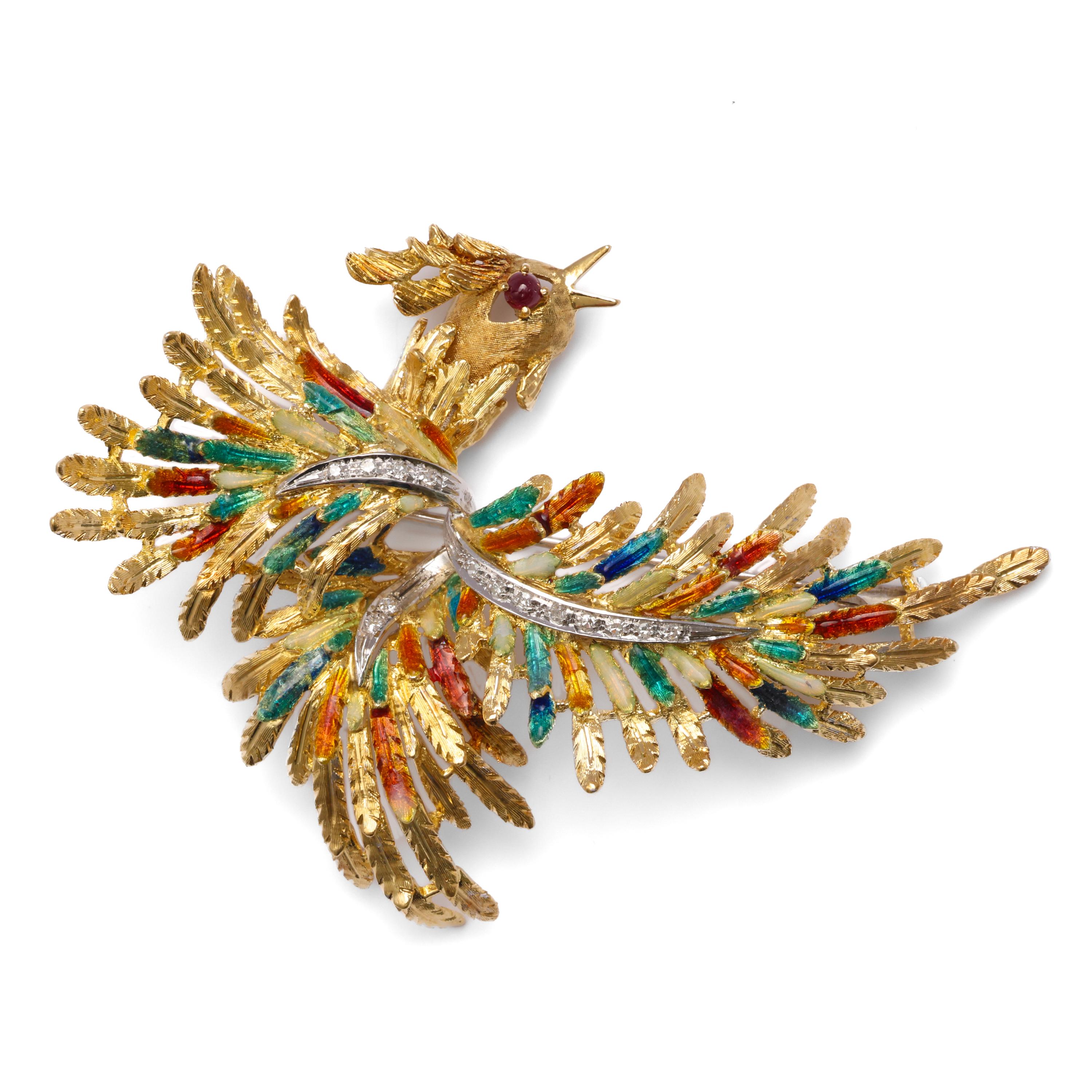 Whimsical and eccentric, this magnificent 18K yellow gold brooch depicts a phoenix bursting with enameled color. A ribbon of white gold set with tiny, brilliant diamonds streaks through the features, creating a sense of shining light. A small ruby