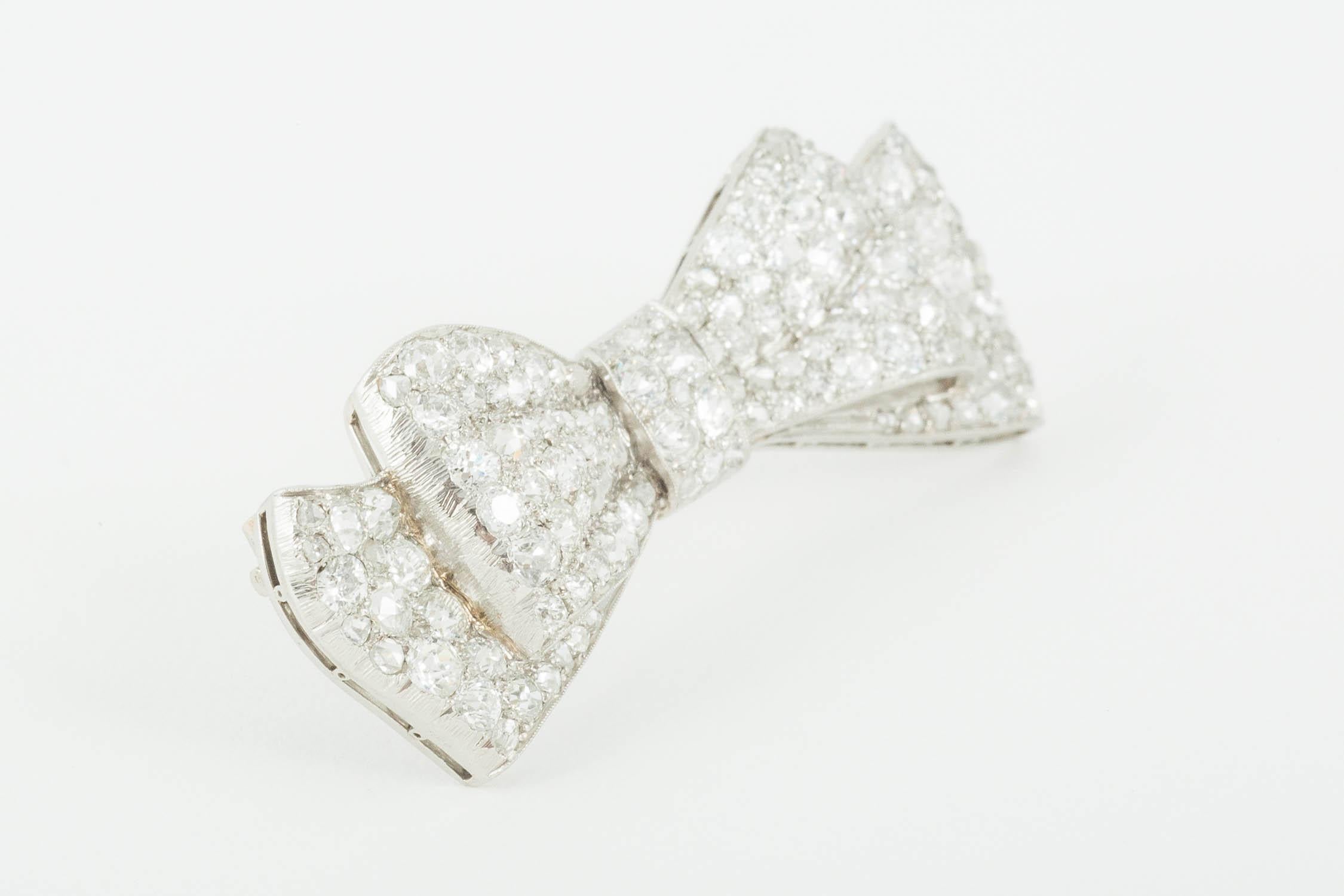 An Edwardian finely made platinum mounted bow brooch, pave set with brilliant and rose cut diamonds of approximately 6 carats. 
Width 45 mm x height 15 mm.
Antique piece (over 100 years old).
Early 20th century, English circa 1920. 

Stock no. 1756