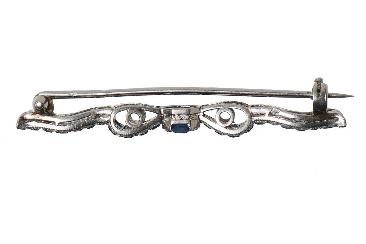 Antique platinum mounted brooch in the design of a slim bow. Set with graduated Ceylon sapphires in a channel setting and edged with rose cut diamonds. French marks to the pin and to the body. Fitted with a safety catch.
Measures 45mm in length x