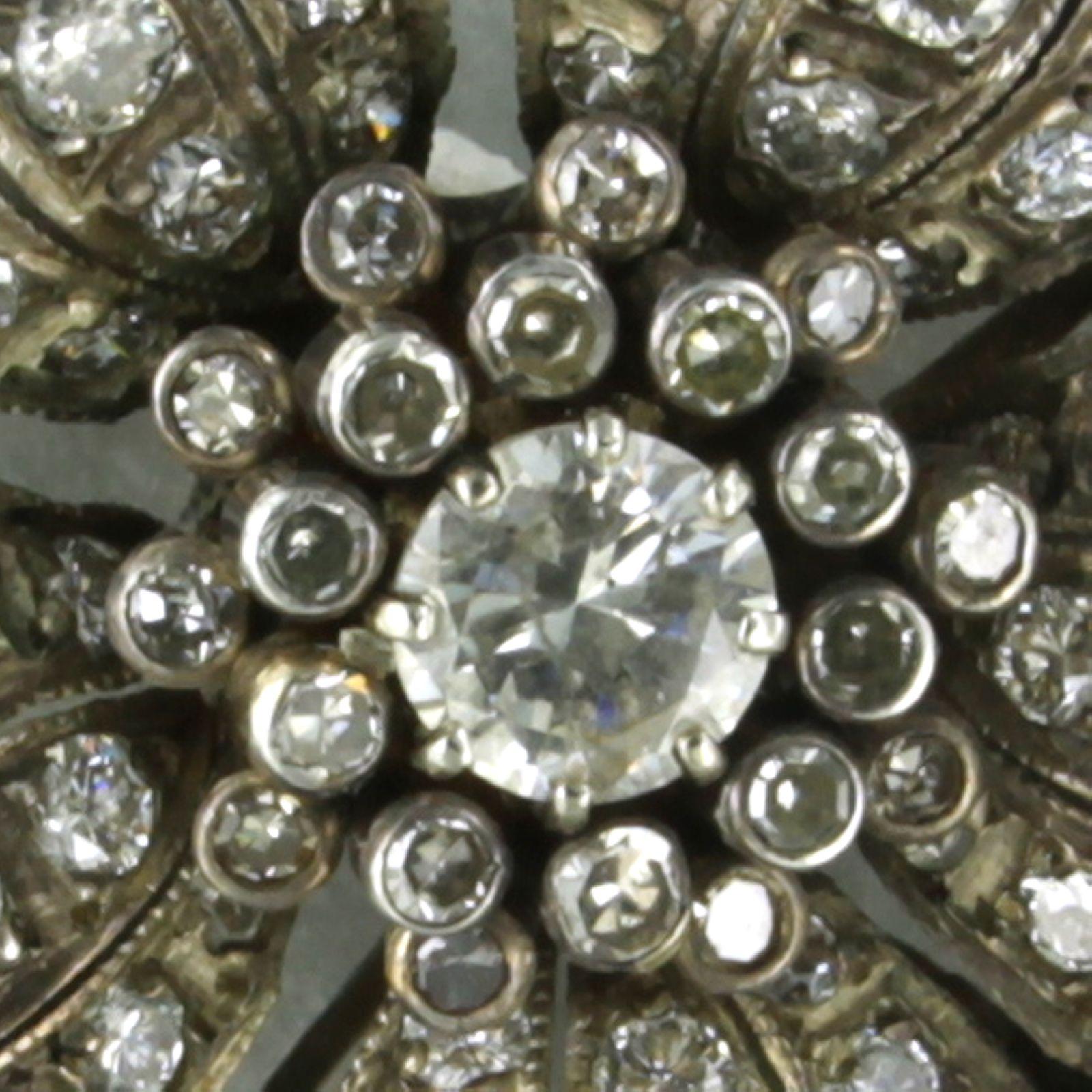 Brosche aus 14 Karat Gold und Silber, besetzt mit Diamanten im Brillant- und Einzelschliff. 2,60ct

detaillierte Beschreibung:

Die Brosche hat einen Durchmesser von 3,2 cm breit und 1,2 cm tief

Gewicht 14,7 Gramm

beschäftigt mit

- 1 x 5,8 mm