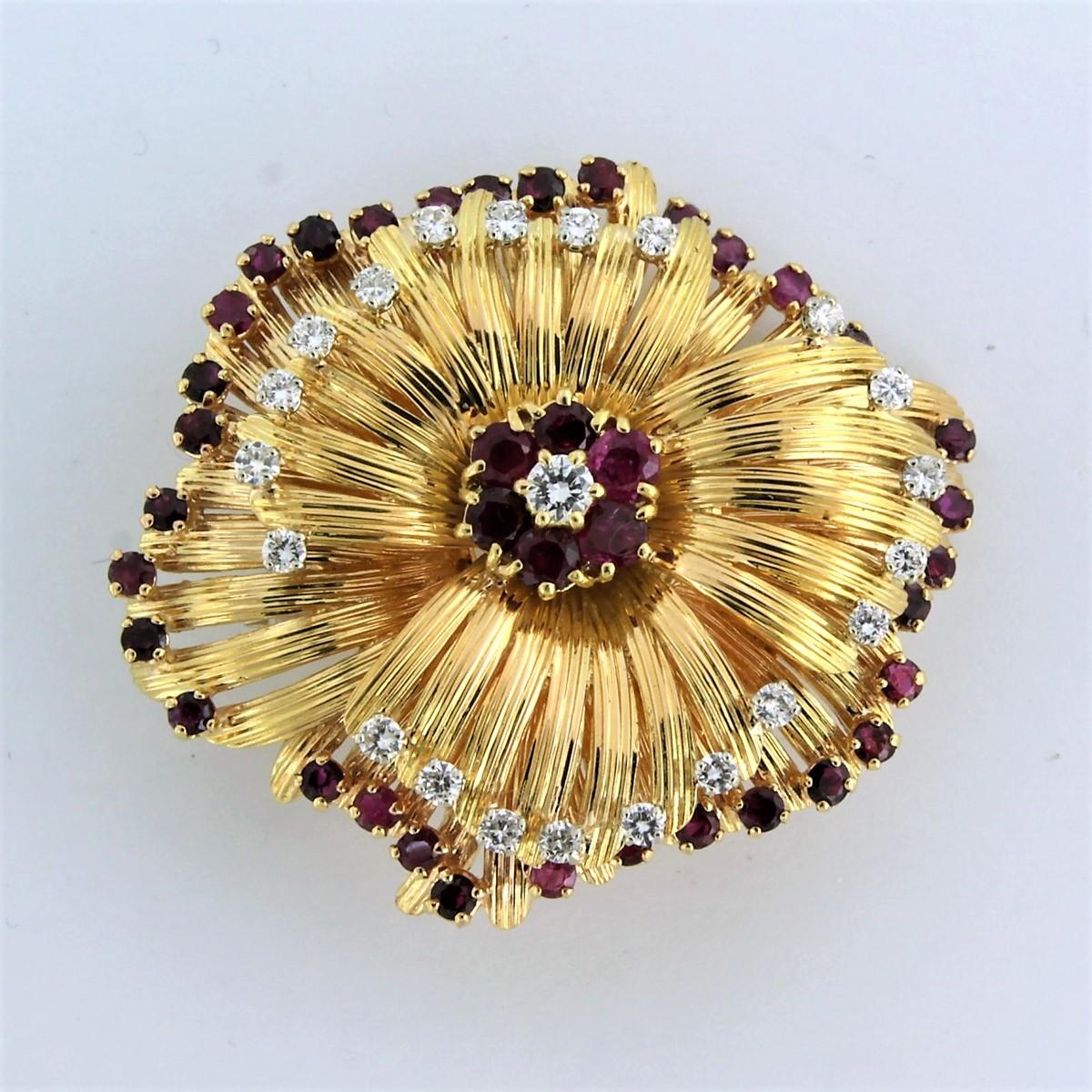 18K yellow gold brooch set with ruby ​​and brilliant cut diamond. 1.00ct - F/G - VS/SI

detailed description:

the size of the brooch is 4.8 cm by 4.1 cm wide

Weight 28.5 grams

Occupied with

- 6 x 3.0 mm round facet cut ruby, approximately 0.30