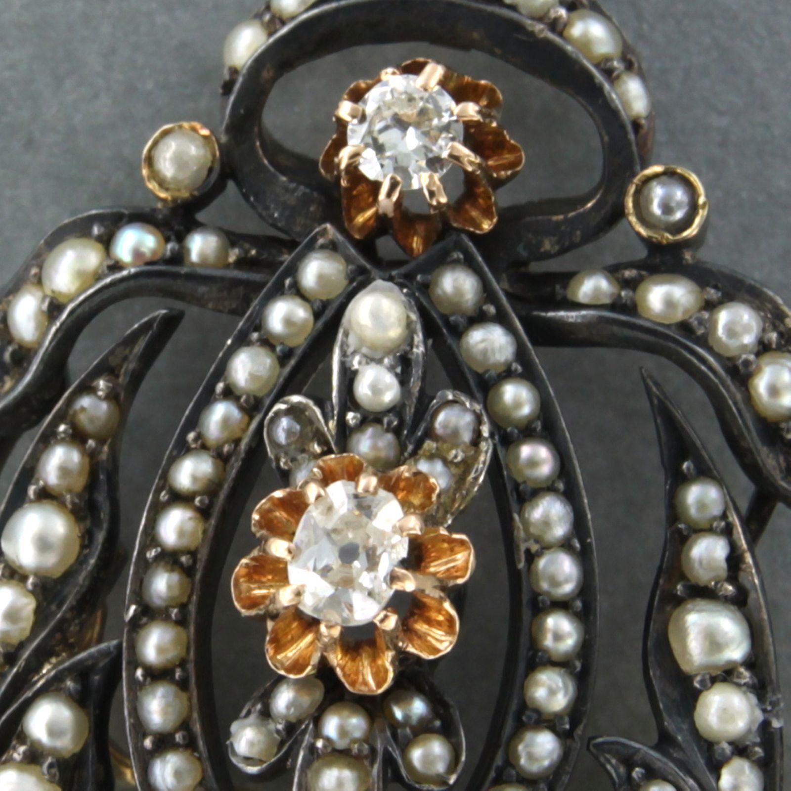 14k yellow gold with silver brooch/pendant with pearls and old mine cut diamonds. 0.35ct - K/L - SI

Detailed description

the size of the brooch/pendant is 6.2 cm by 2.9 cm wide 

weight 14.3 grams

set with

- 108 x 1.5 mm – 3.0 mm pearls 

color