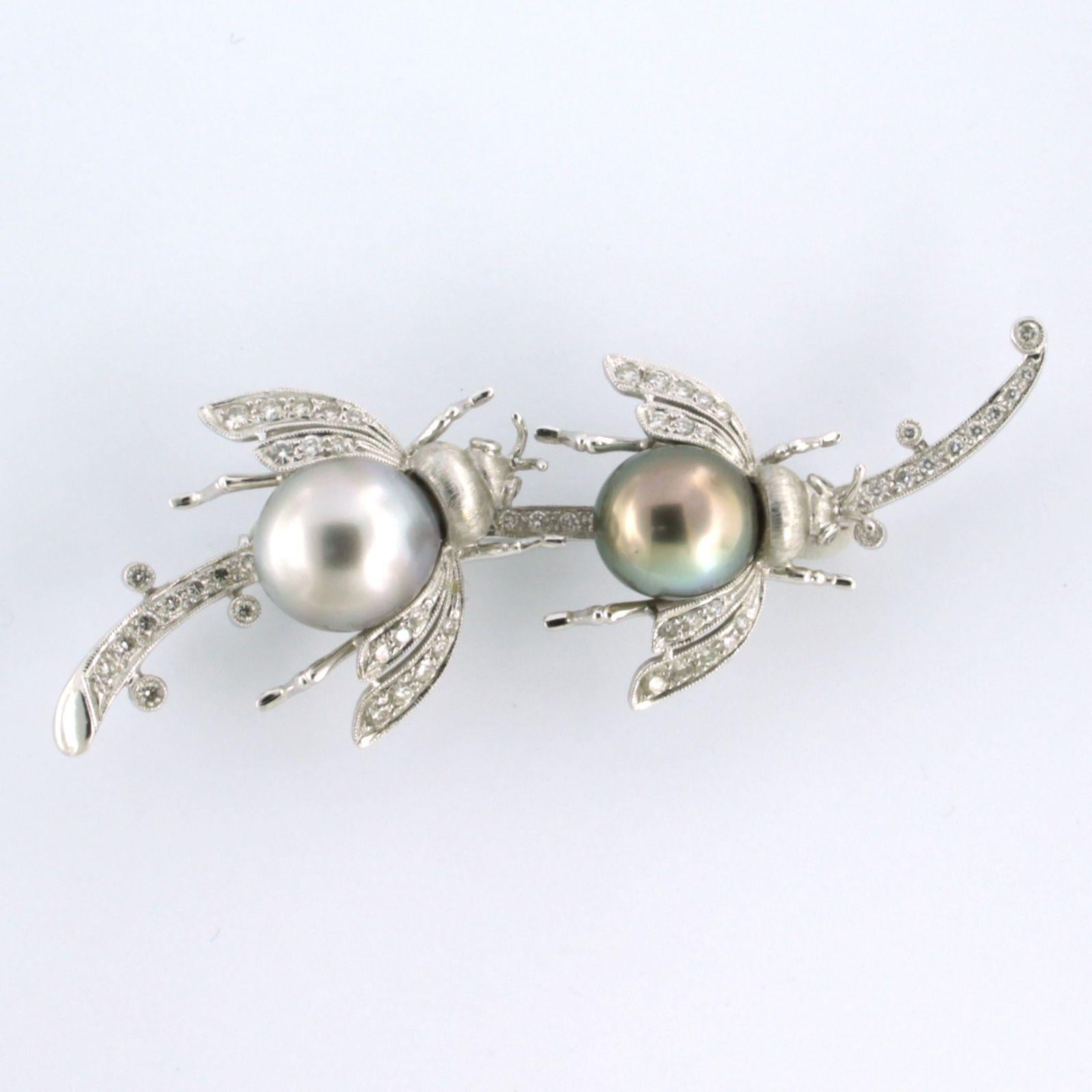 18k white gold brooch Two Bees on a twig, set with tahiti pearl and diamond total 0.60 carat – H/I – SI

Detailed description

the size of the brooch is 7.5 cm by 2.7 cm wide

weight 18.0 grams

put with

- 2 x 1.0 cm Tahiti pearls

color grey and