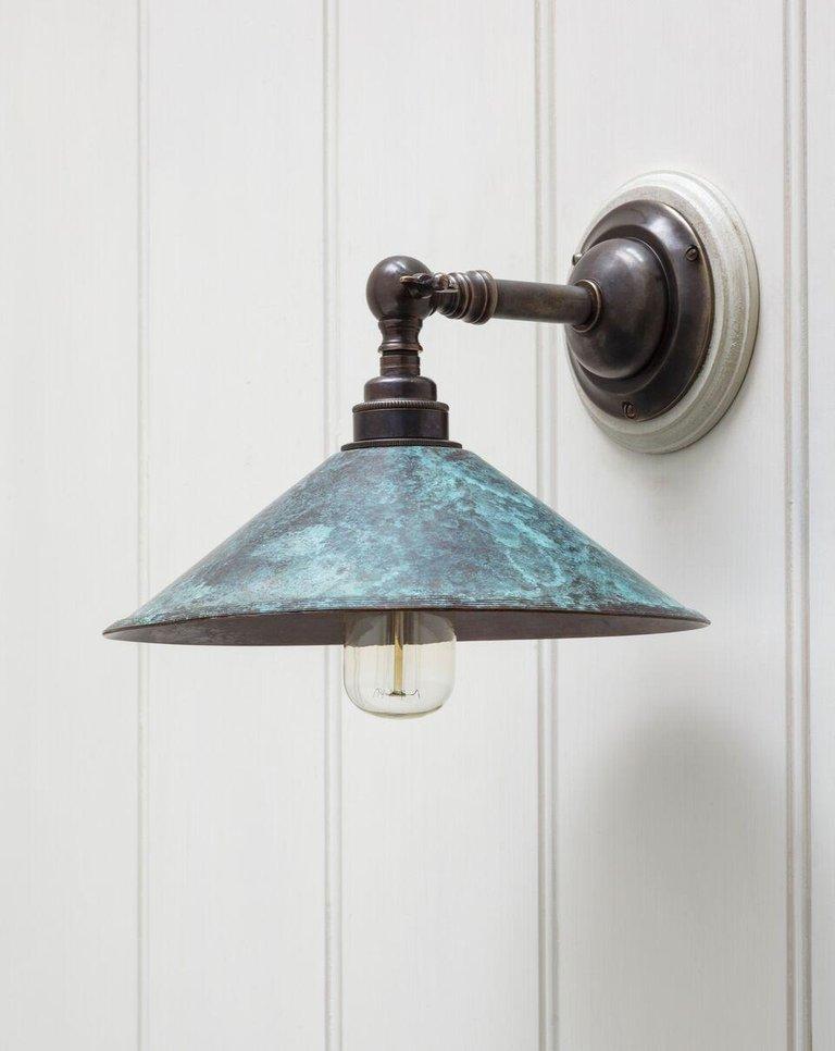 A swivel wall lamp with ringed collared shaft protruding from a rounded base. The reeded metal shade attached to a ball shaped gimbal with locking tap. Please note the fixture is shown in a number of alternative finishes. Please ask about these