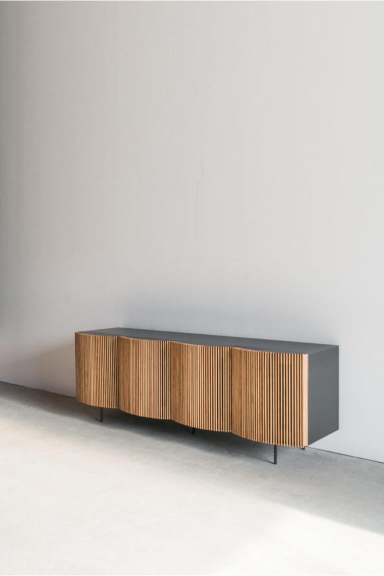 La credenza Brooks è realizzata a mano a Los Angeles, in California. Il design raffinato del pezzo trae la sua estetica originale dalla combinazione del classico involucro metallico e del rivestimento in rovere accuratamente assemblato. L'involucro