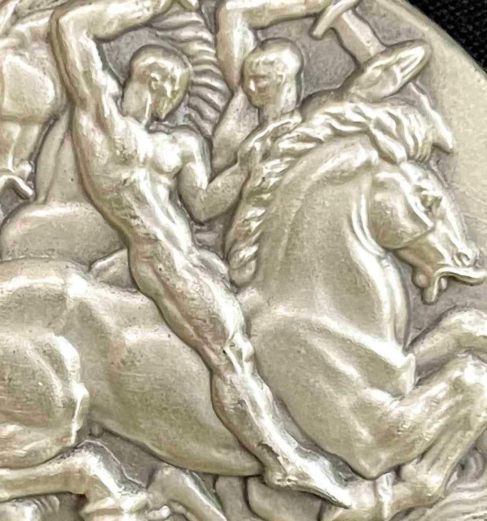 A brilliant and rare example of late Art Deco sculpture struck in solid silver, this medal was designed by Donald De Lue in 1965 as part of the larger New York University Hall of Fame for Great Americans Series.  On one side it depicts two nude