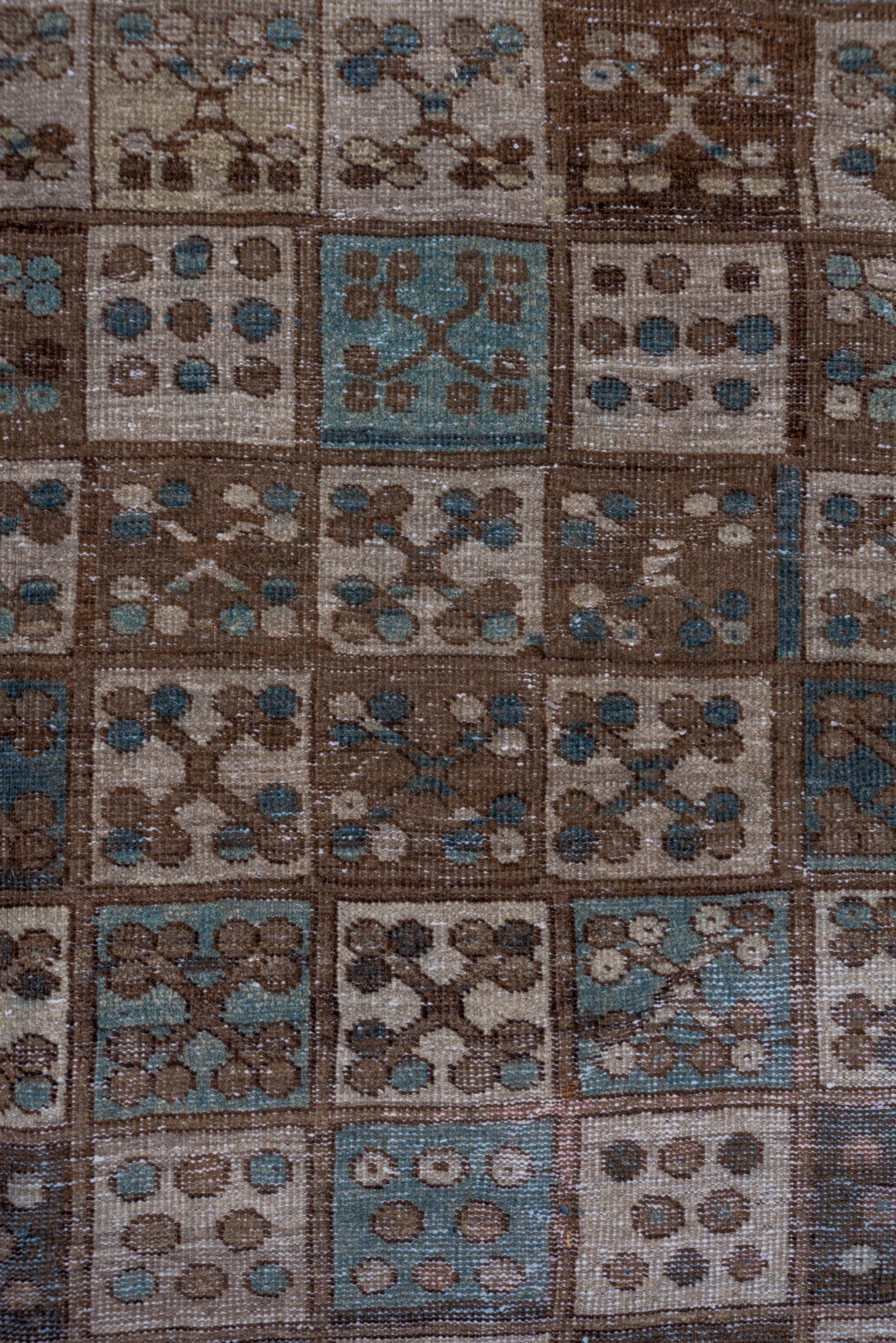 The field is completely covered by a six column square pattern with four trefoil flowers in each panel. Turkmen-style hooked lozenge-in-square border. Browns and beiges predominate with a few patches of light blue.
