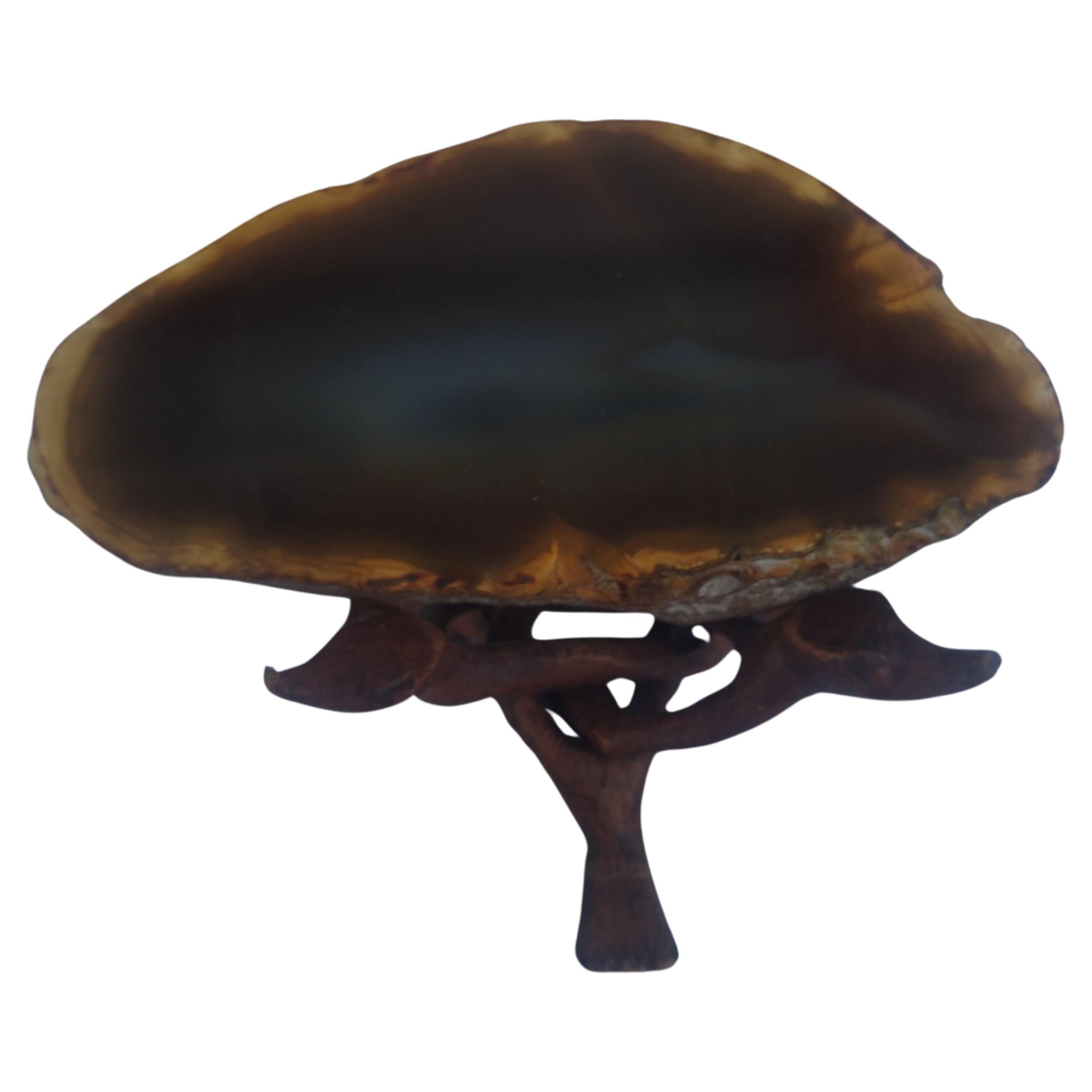 Questo è un geode di agata marrone proveniente dal Brasile. La sua tonalità è molto ricca. Si trova su una base a treppiede in legno intagliato con incastro. Il bellissimo geode di agata marrone è incrostato all'interno di una roccia di colore