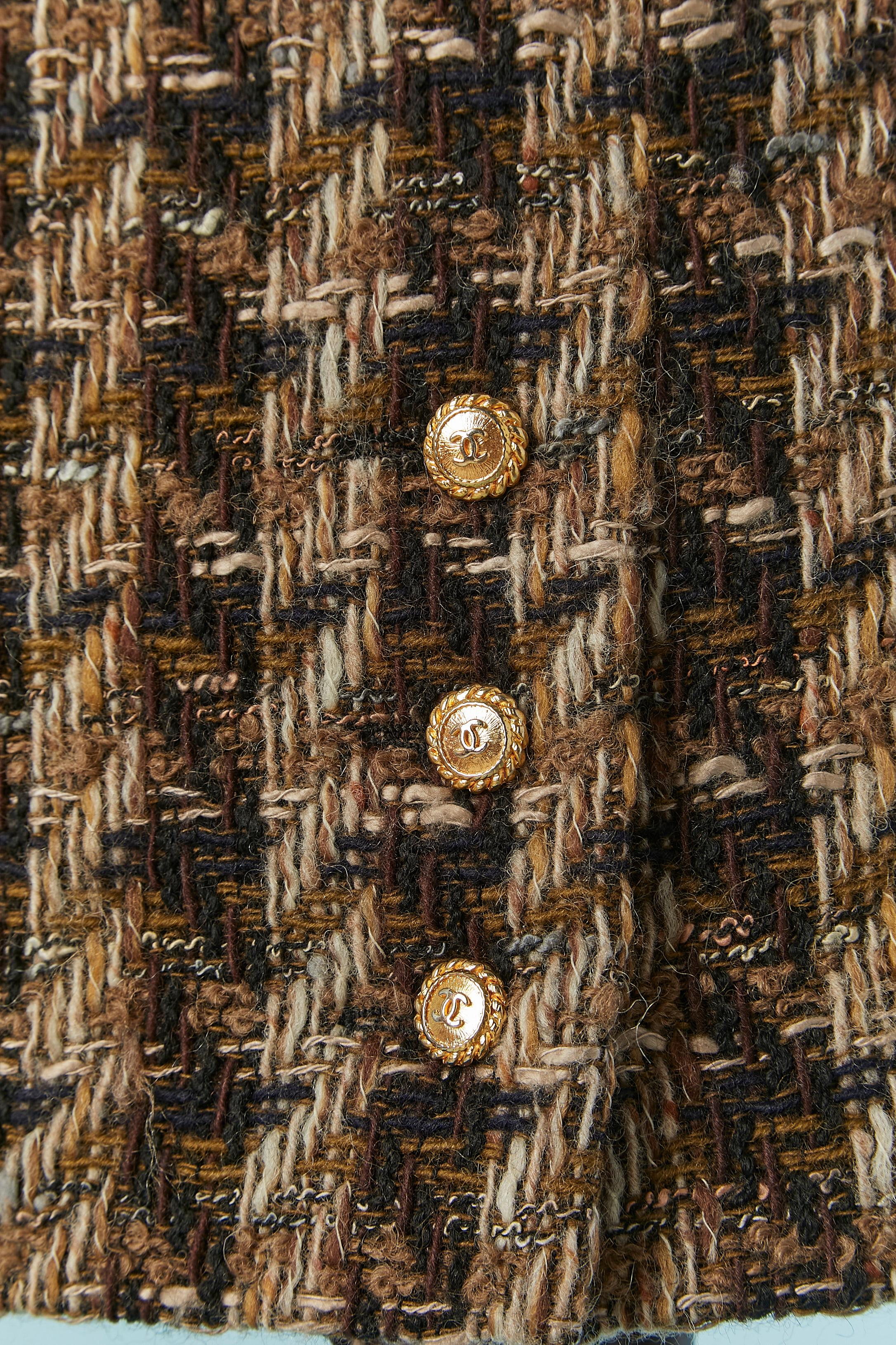 Brown and beige Tweed skirt with gold metal branded button on the front side. Tweed composition: 93% wool, 7% acrylic. Silk branded lining. 
Zip and hook&eye closure on the middle back. 
SIZE 34 (Fr) XS 