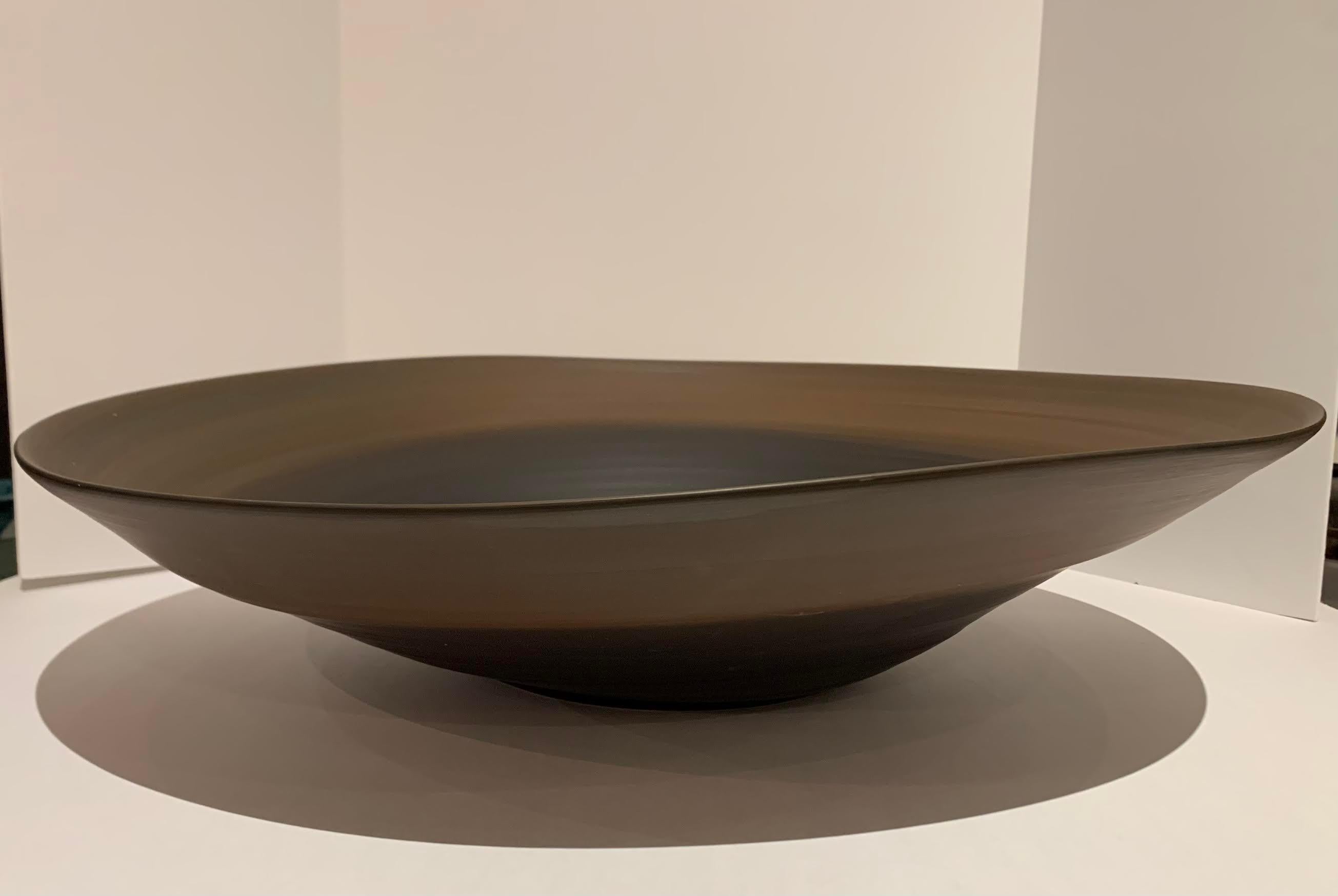 Coffee and black circular design contemporary Italian extra large fine ceramic bowl.
The black center is surrounded by a beautiful coffee color rim.
On the exterior, the black base is topped by the coffee color rim.
The bowl is handmade and has