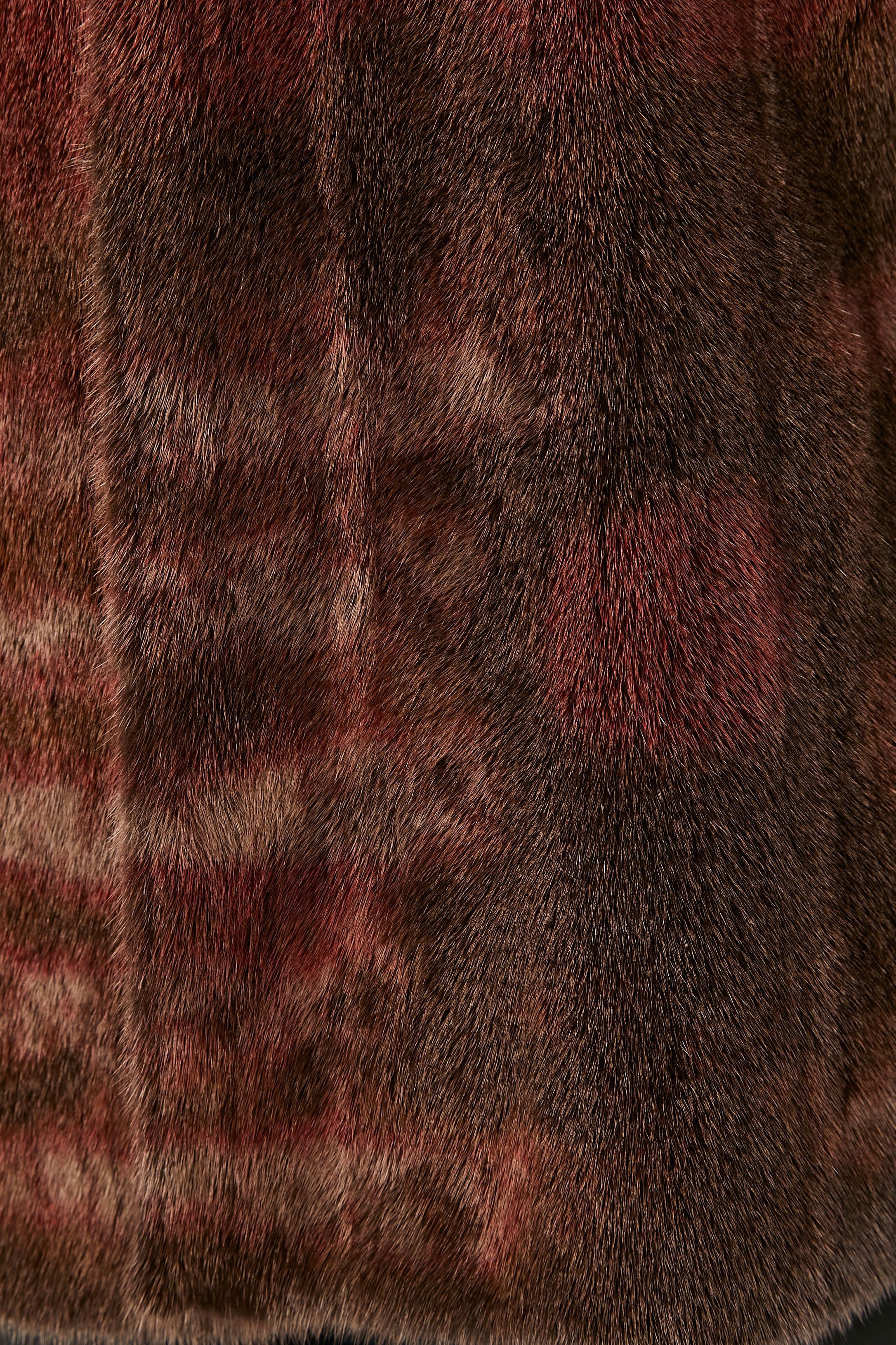 Gilet in visone marrone e bordeaux. Fodera in seta con profili in pelle scamosciata nera. Chiusura ad occhiello sulla parte centrale della fronte. 
Tasca su entrambi i lati. 
TAGLIA 38 (Fr) M 