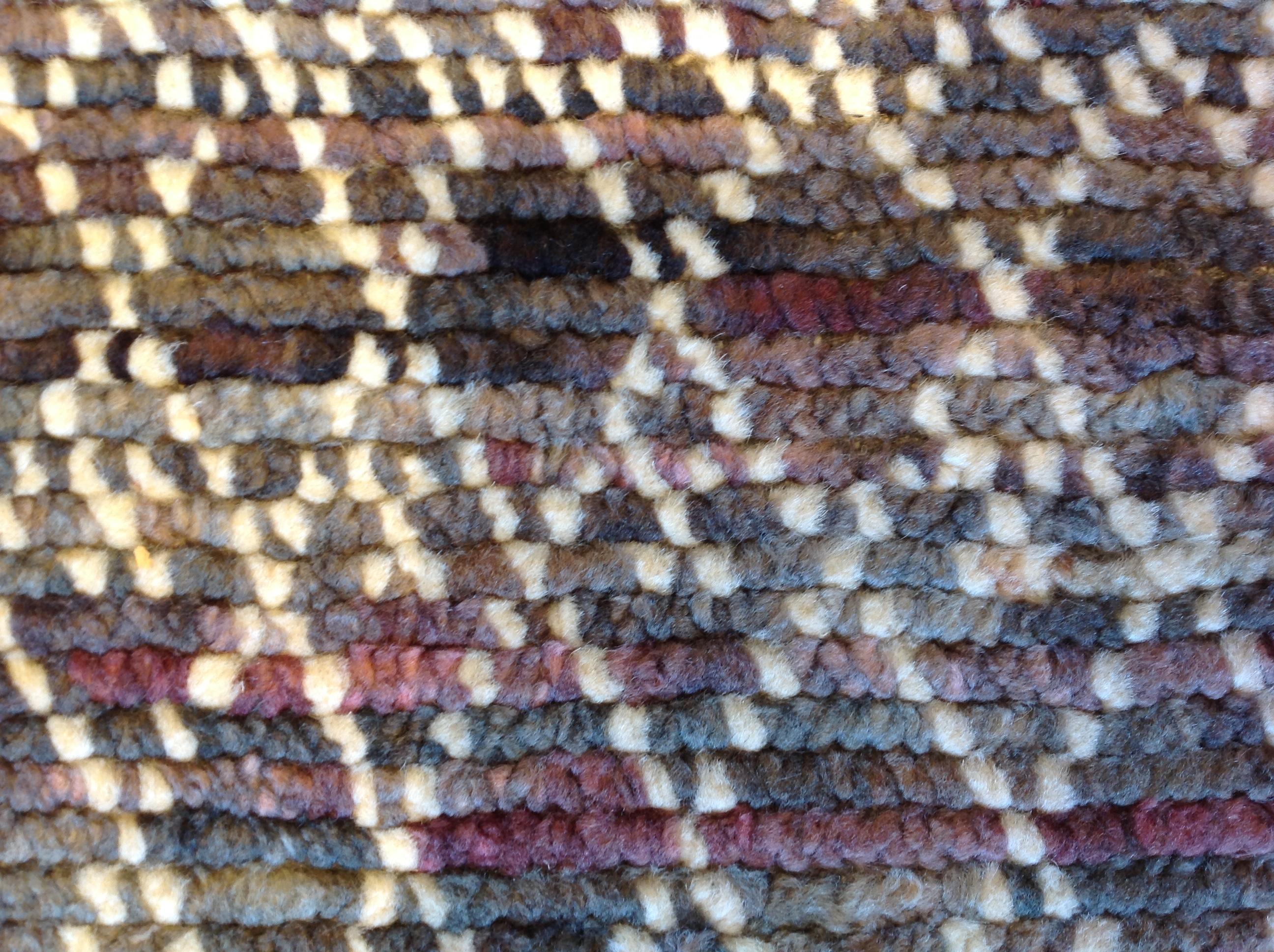 Braun- und Burgundertöne bilden einen farbenprächtigen Kontrast zu dem elfenbeinfarbenen Kreuzmuster. Wolle, Viskose und Baumwolle sorgen für einen genoppten Griff und eine strapazierfähige Konstruktion. Handgefertigt in Indien mit pflanzlichen