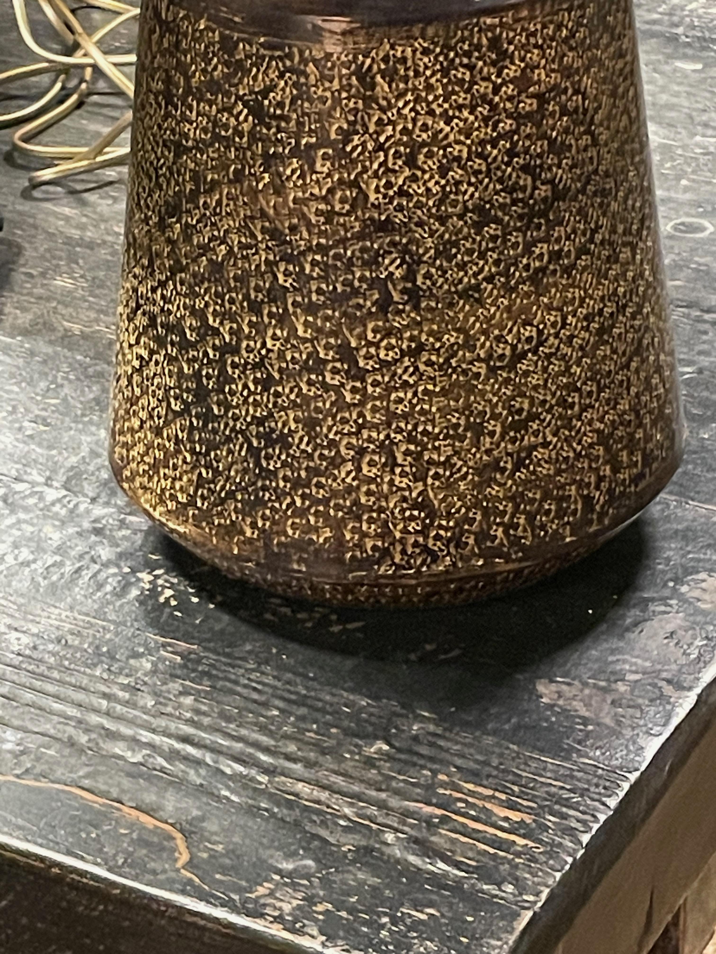 Lampe simple chinoise contemporaine en métal texturé.
Le dessus de la base est orné d'un motif décoratif marbré brun et or.
Le fond de la base est solide.
Abat-jour en lin belge inclus.
Diamètre de l'abat-jour 16