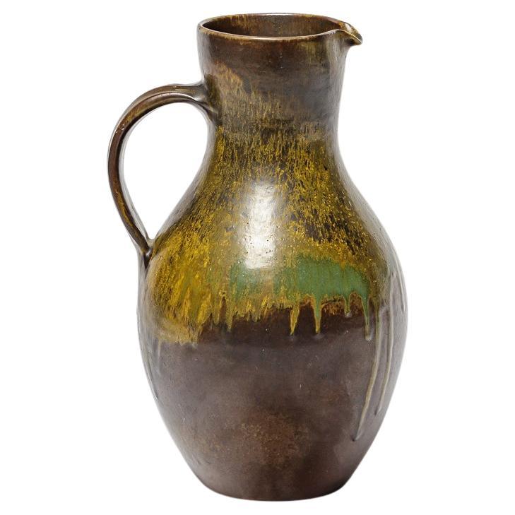 Brown and green glazed ceramic pitcher by Roger Jacques, circa 1960-1970. For Sale
