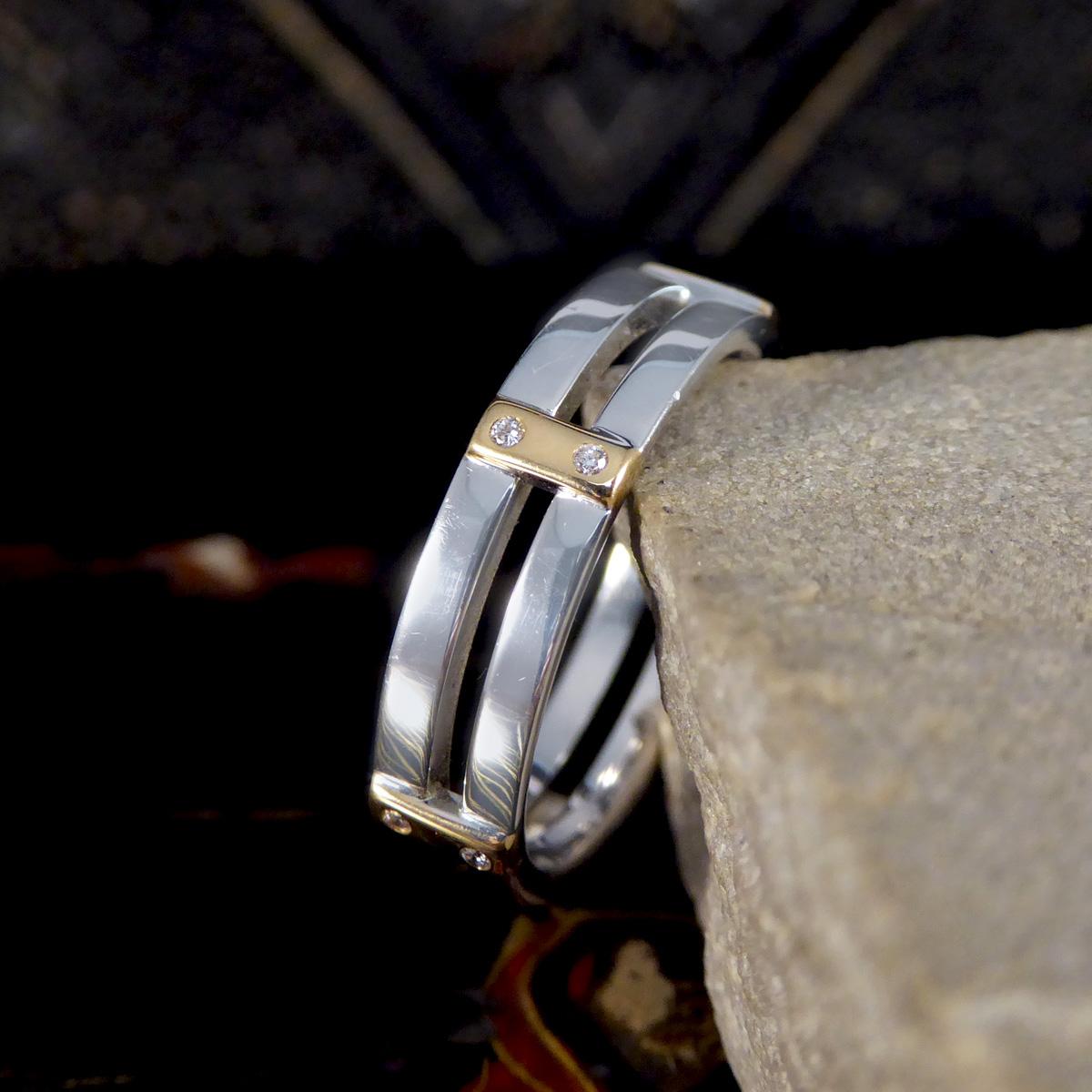 This Brown and Newirth two tone Diamond set bar band ring is a masterpiece of modern craftsmanship and design, elegantly crafted in 18ct gold. This exquisite ring features a sophisticated two-tone design, blending the warm, classic appeal of yellow