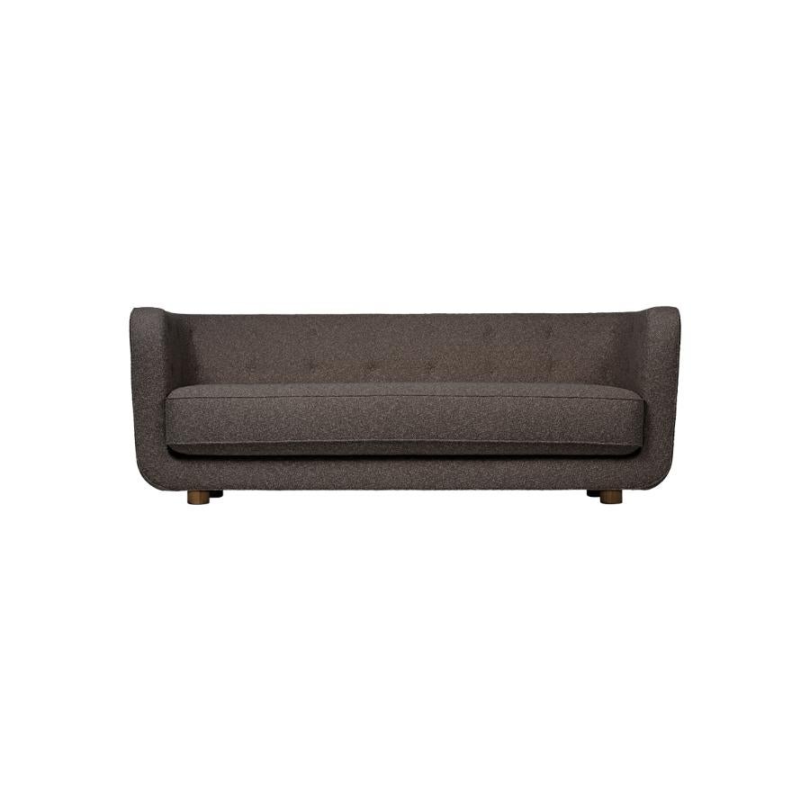 Brown and smoked oak sahco nara vilhelm sofa by Lassen.
Dimensions: W 217 x D 88 x H 80 cm 
Materials: Textile, oak.

Vilhelm is a beautiful padded three-seater sofa designed by Flemming Lassen in 1935. A sofa must be able to function in several