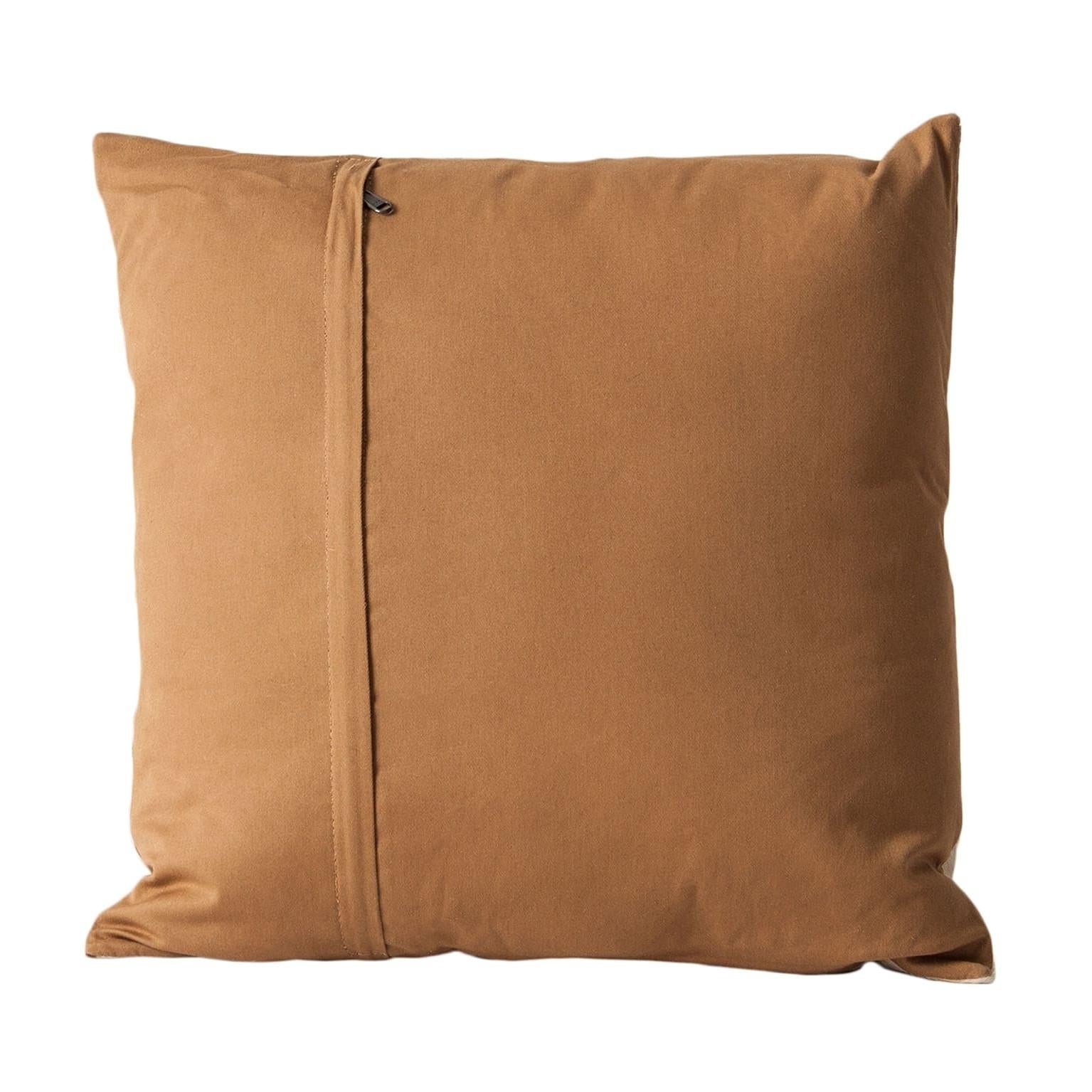 Brown and white cowhide cushion.