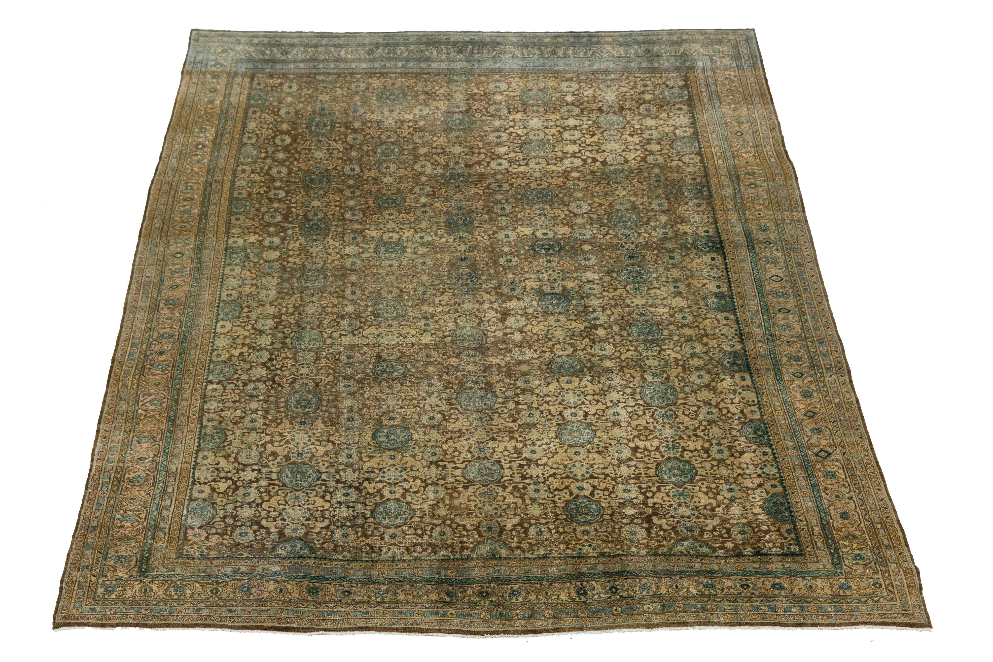 Questo antico tappeto persiano in lana Bidjar mostra una notevole abilità artigianale annodata a mano. Il ricco campo marrone è splendidamente ornato da un elegante disegno floreale all-over, evidenziato da sofisticati accenti verdi e beige. Questo