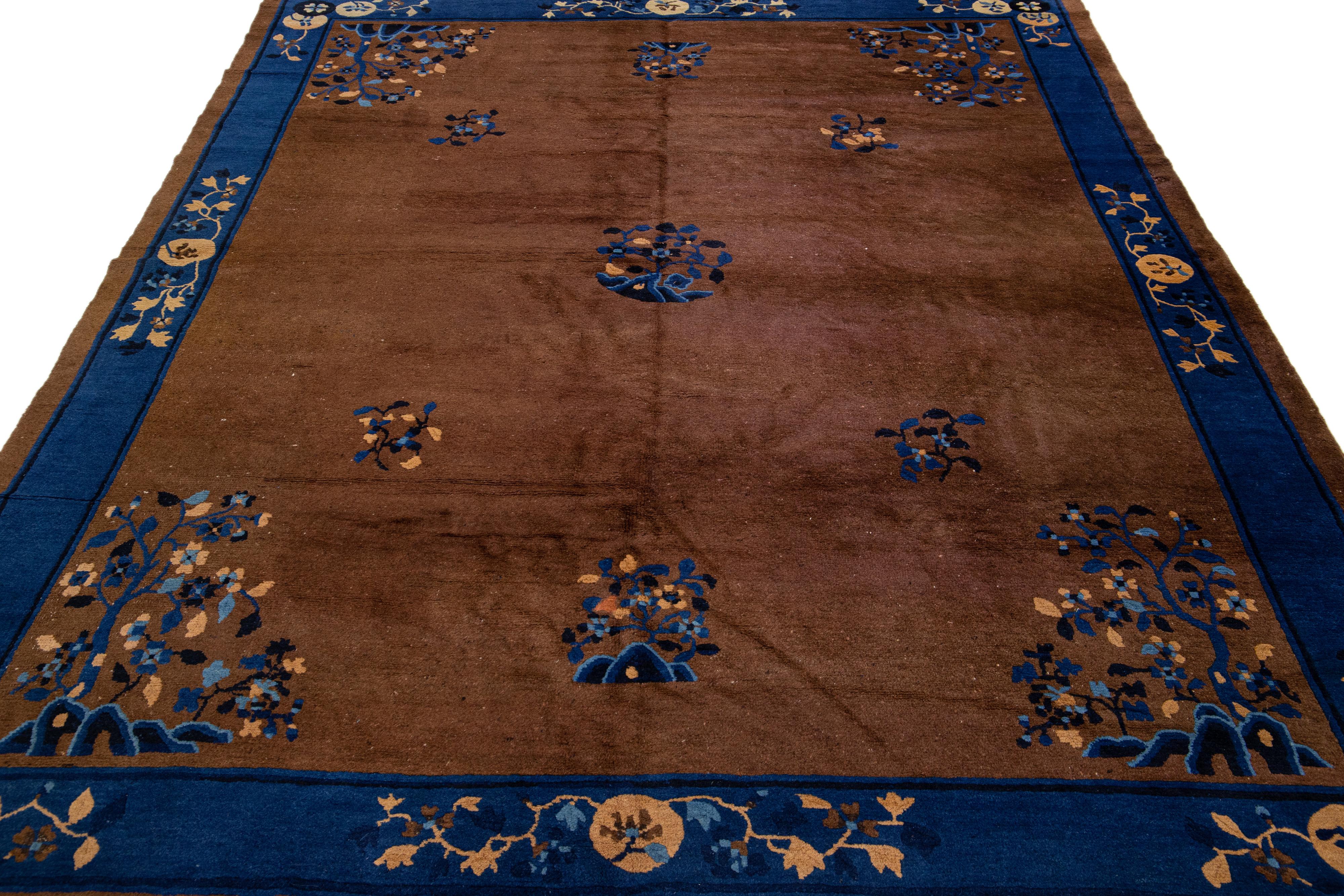 Schöner antiker Art-Déco-Teppich aus handgeknüpfter Wolle mit braunem Feld. Dieser chinesische Teppich hat einen blauen Rahmen und eine hellbraune Akzentfarbe mit einem prächtigen chinesischen Blumenmuster. 

Dieser Teppich misst: 7'8
