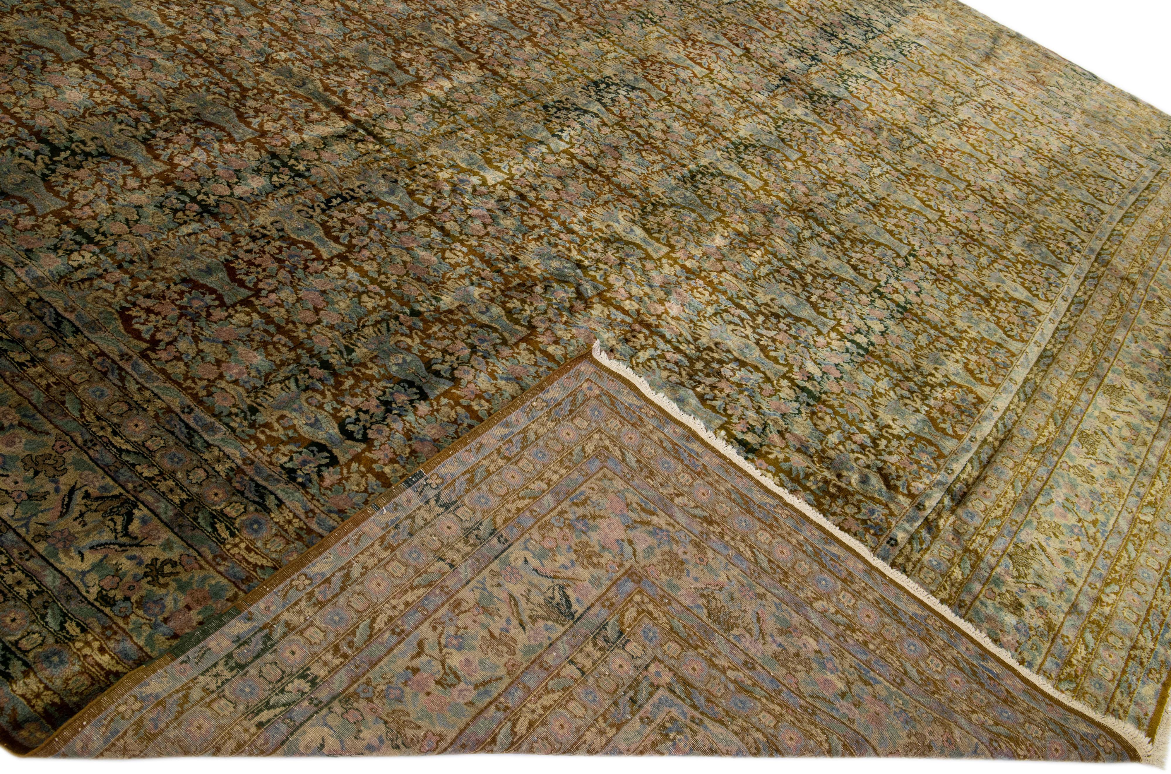 Schöner antiker, handgeknüpfter Agra-Wollteppich mit braunem Feld. Dieser indische Teppich hat rosa und blaue Akzente in einem wunderschönen floralen Allover-Muster.

Dieser Teppich misst: 14'5