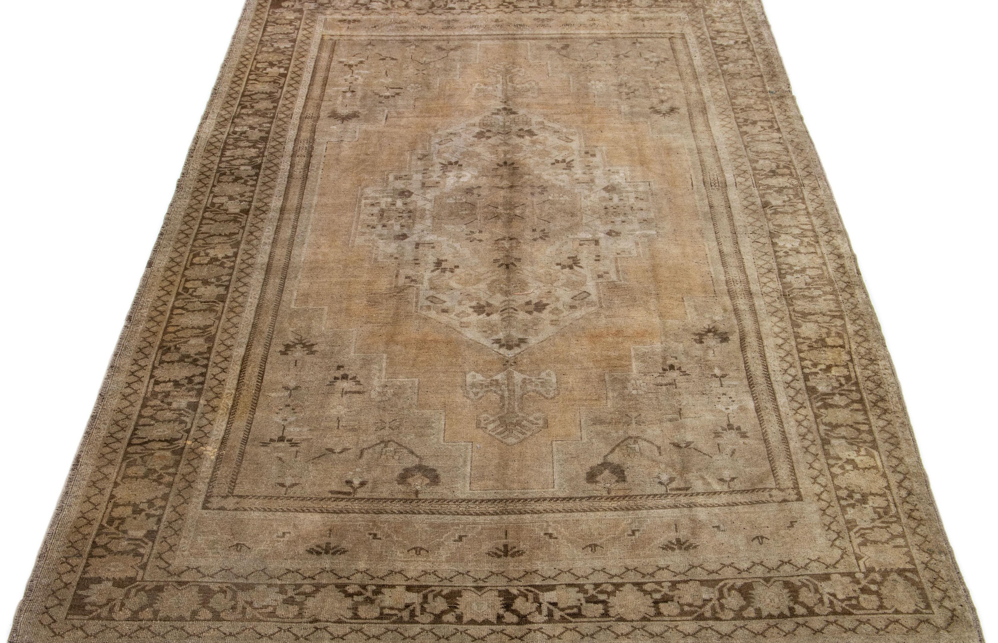 This antique Turkestan Khotan rug features a charming tan background illuminated by elegant peach and brown accents arranged in an intricate central medallion design.

This rug measures 7'6