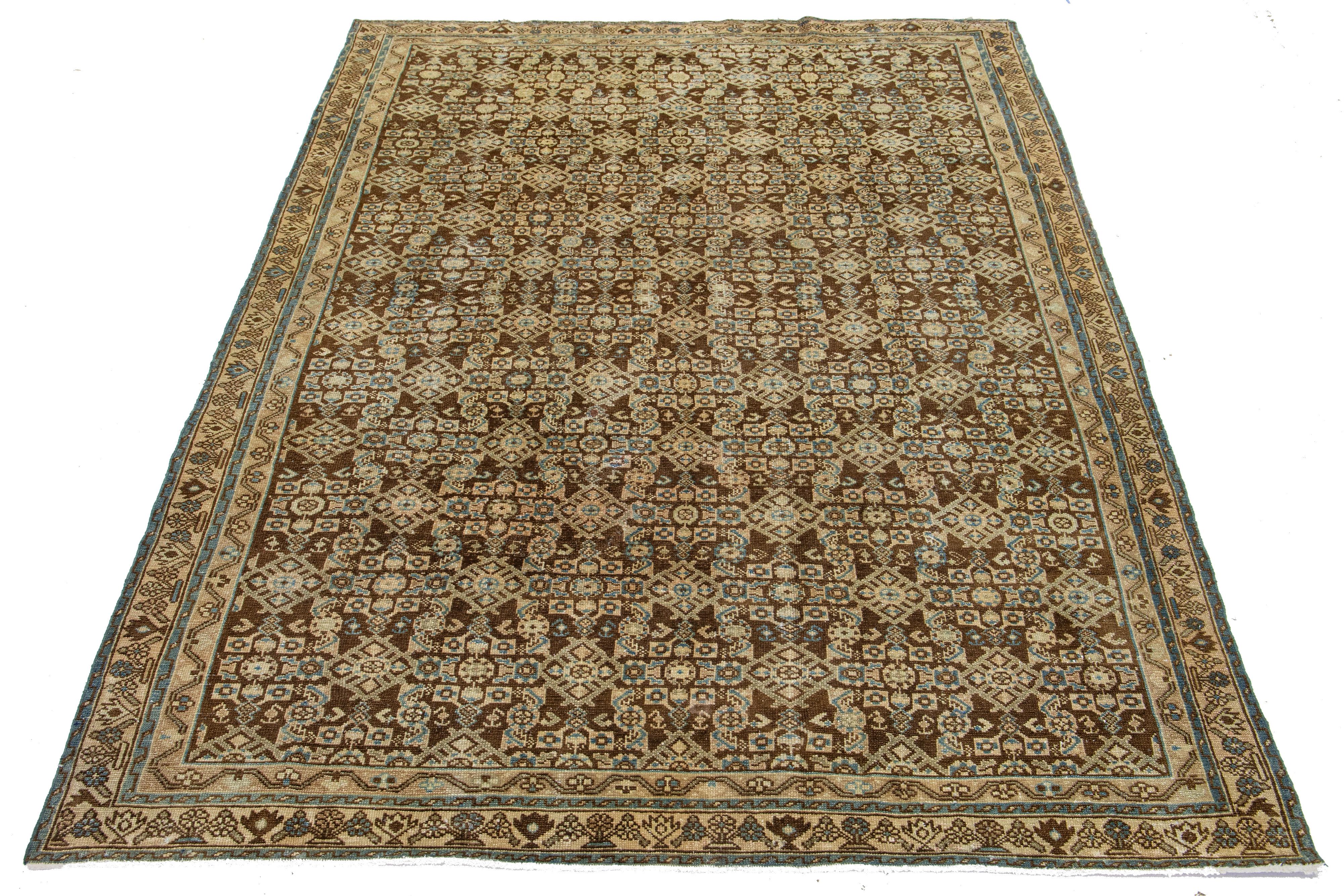 This is a handmade Persian Malayer rug from the 20th century. It has a brown field with blue and beige accents throughout the design.

This rug measures 6'6
