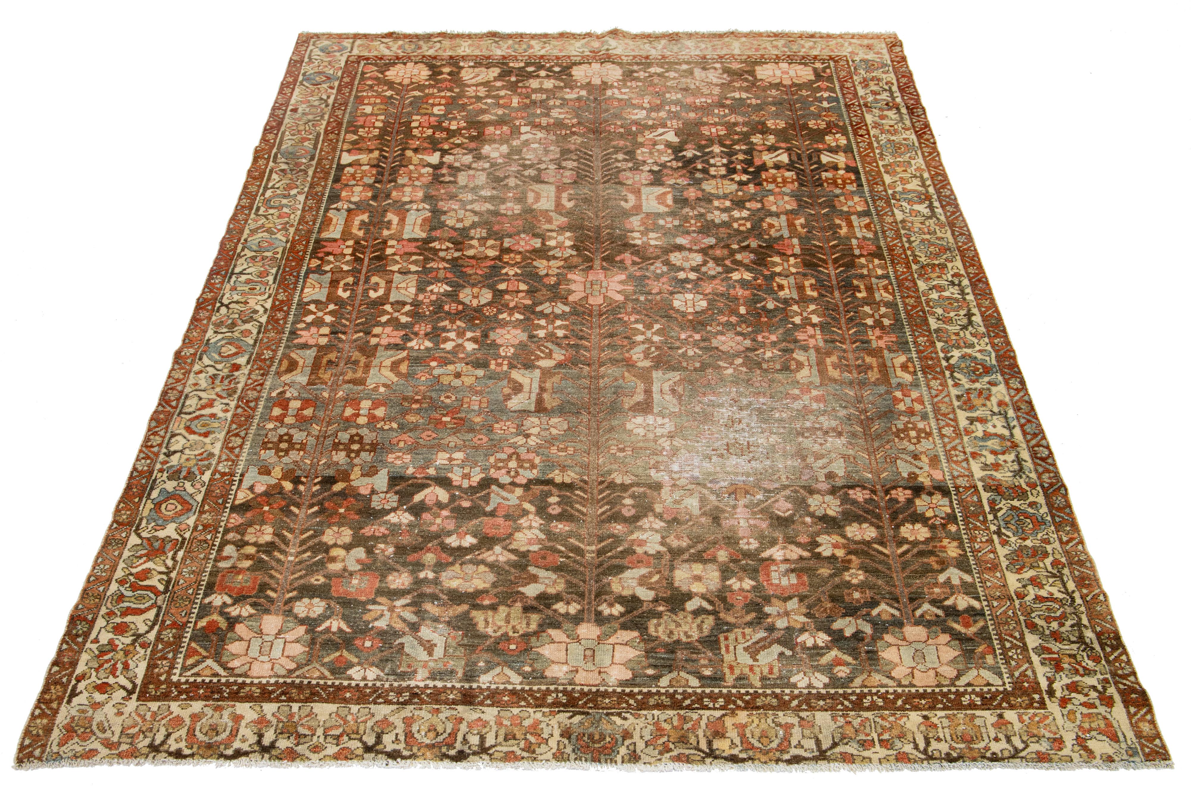 This room-size antique Hamadan hand-knotted wool rug is beautiful, featuring a brown color field. It showcases a stunning allover floral design in the Persian style with accents of blue, beige, and peach.

This rug measures 6'9