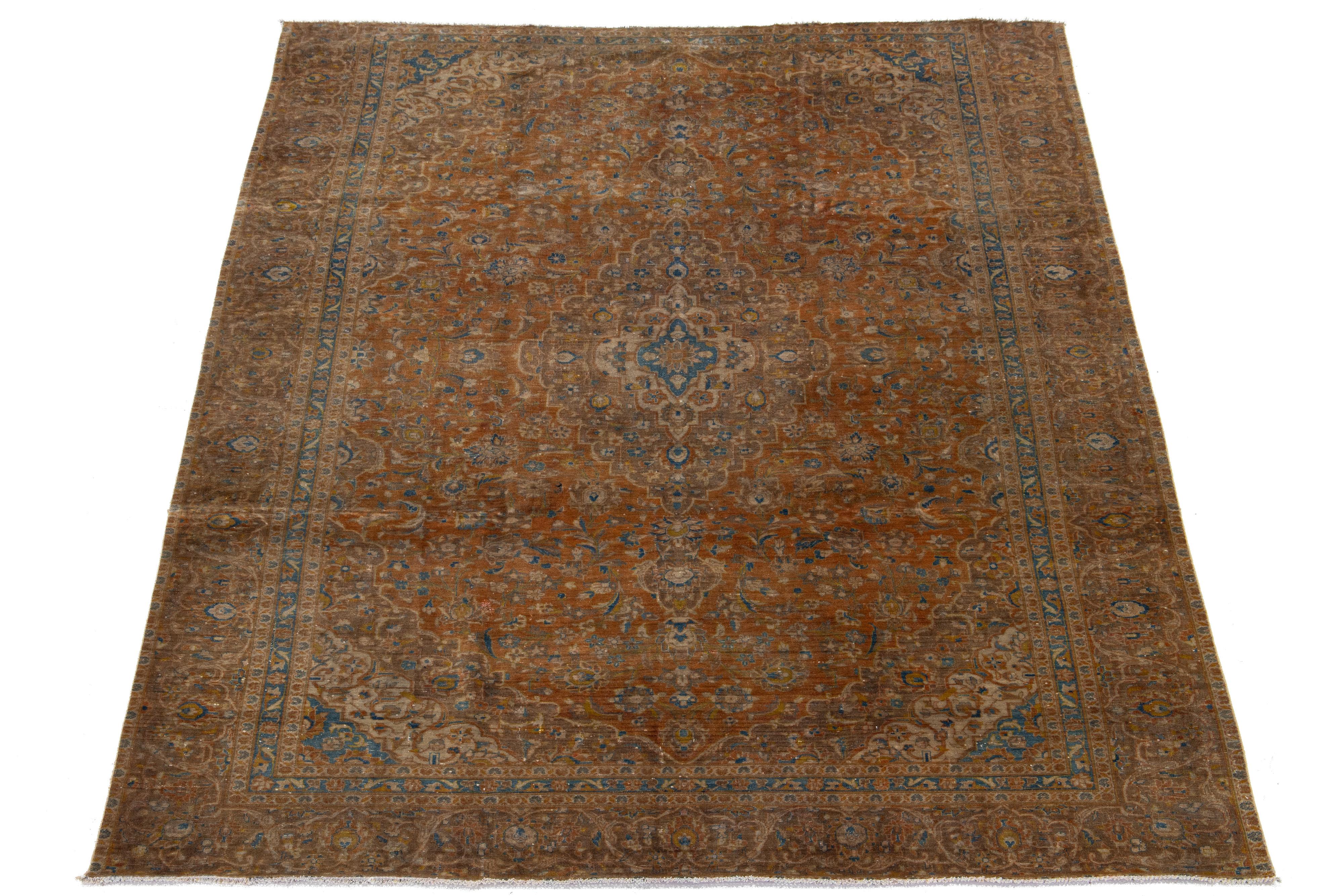 Dieser antike persische Täbriz-Teppich aus den 1910er Jahren zeigt ein atemberaubendes blaues Feld, das mit einem komplizierten Blumenmuster verziert ist und von kräftigen roten und braunen Akzenten unterstrichen wird.

Dieser Teppich misst 8'11