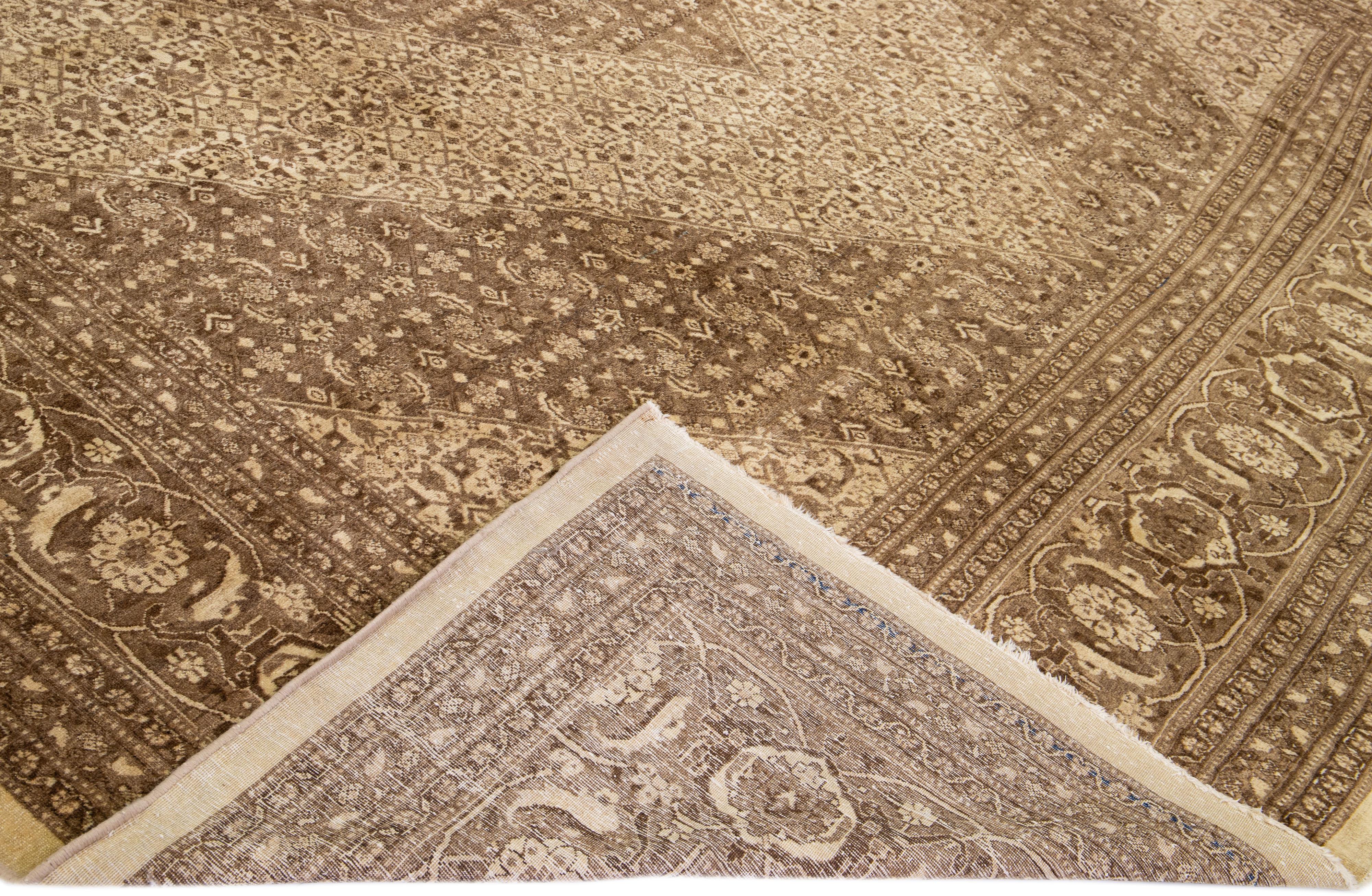 Beautiful antique Tabriz hand-knotted wool rug with a brown field. This Persian piece has beige accents in a gorgeous all-over floral design. 

This rug measures: 12'9