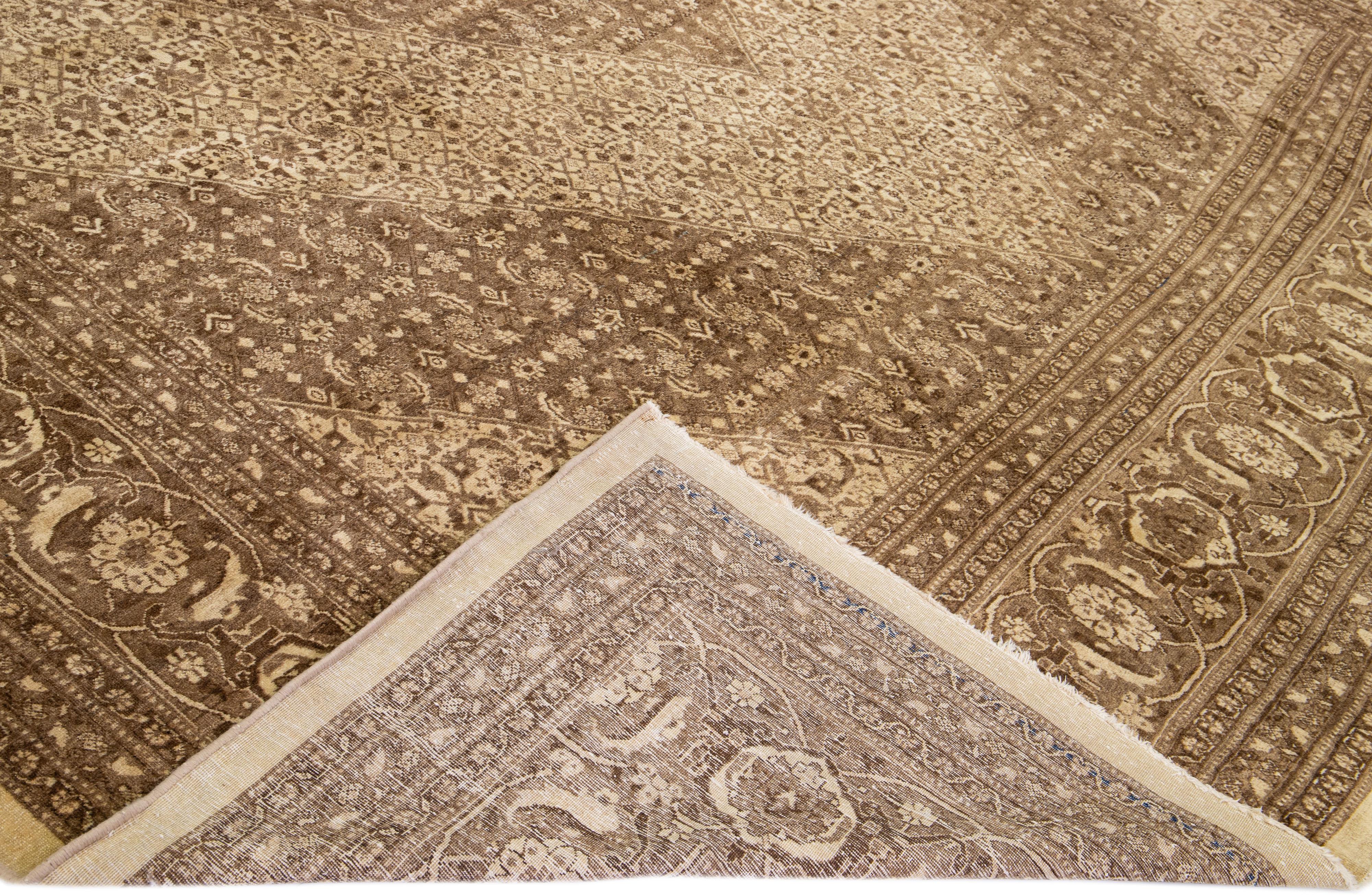 Magnifique tapis antique Tabriz en laine nouée à la main avec un champ brun. Cette pièce persane présente des accents beiges dans un magnifique motif floral intégral. 

Ce tapis mesure : 12'9