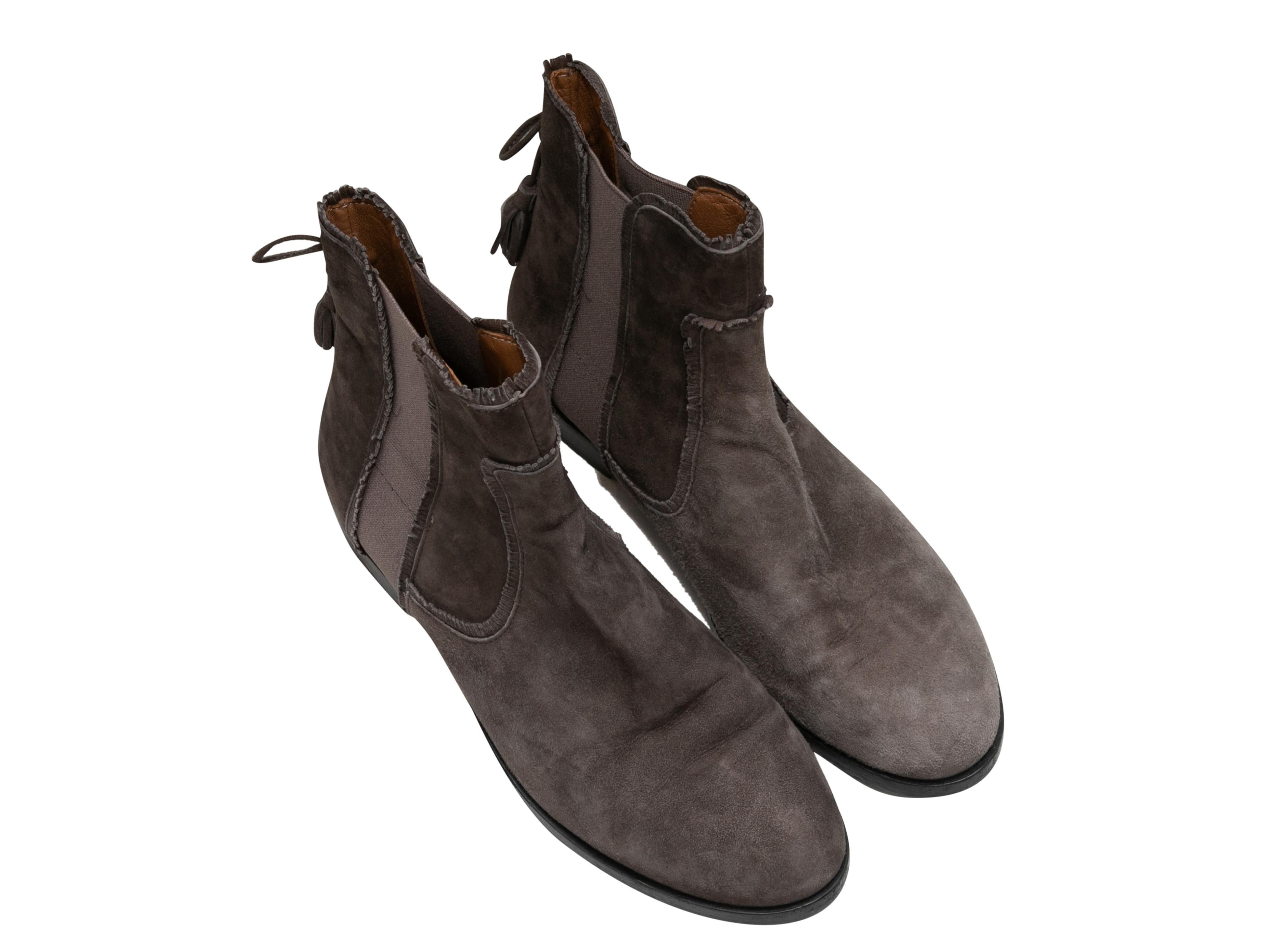 Stivaletti piatti in camoscio marrone di Aquazzura. Accenti di nappe sui banconi. Elastici ai lati. Altezza del gambo 5,5
