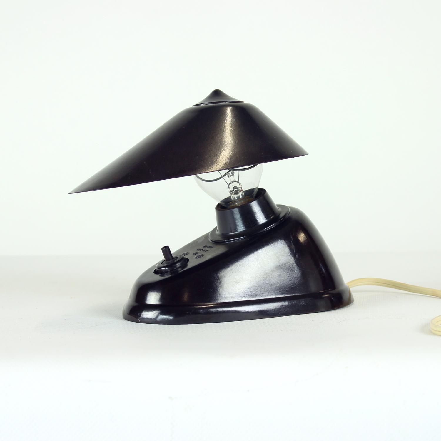 An exceptional example of Bauhaus-era industrial design, this dark brown bakelite desk lamp combines functionality, innovation, and timeless form. Originally designed in the 1930s by the Bauhaus design team, it was produced in Czechoslovakia by ESC